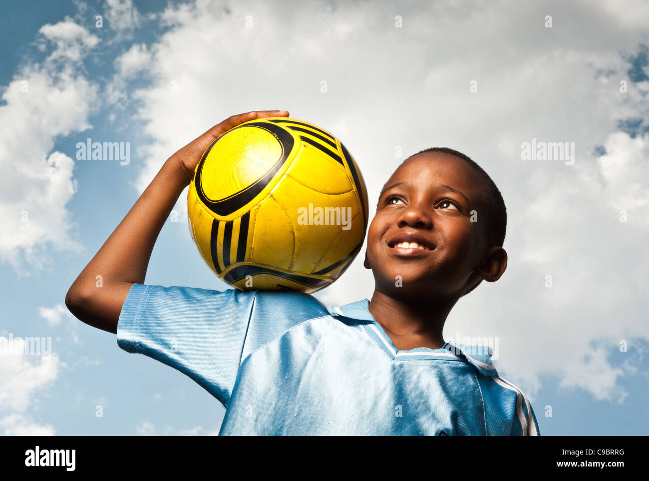 Ragazzo tenendo il calcio all'aperto, Johannesburg, provincia di Gauteng, Sud Africa Foto Stock