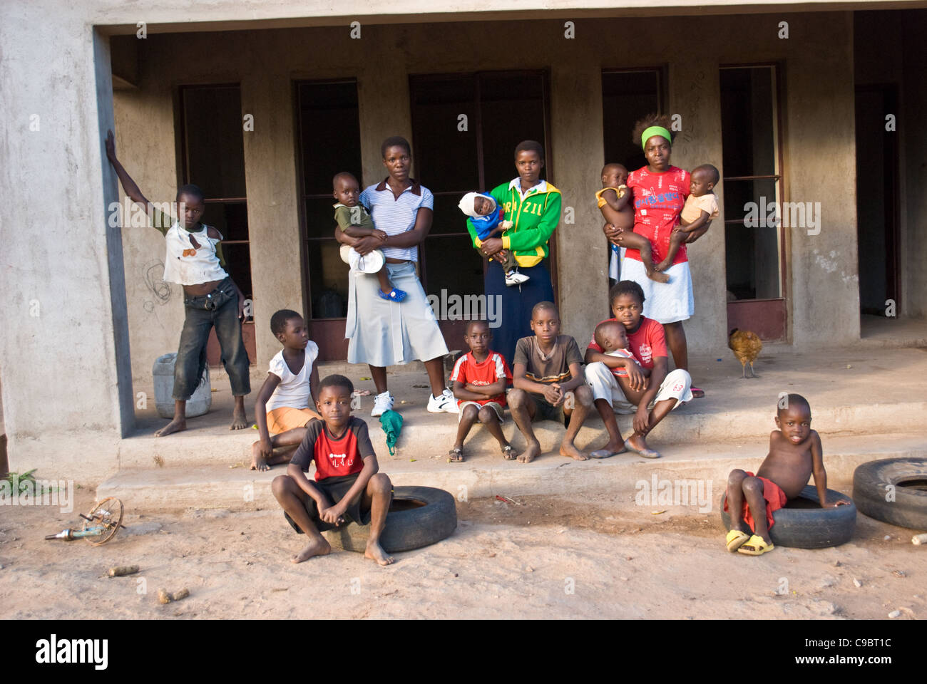 Una famiglia estesa di donne e adottato gli orfani di AIDS squatting in una metà costruita casa abbandonata dai suoi proprietari in bianco di Bulawayo. Foto Stock