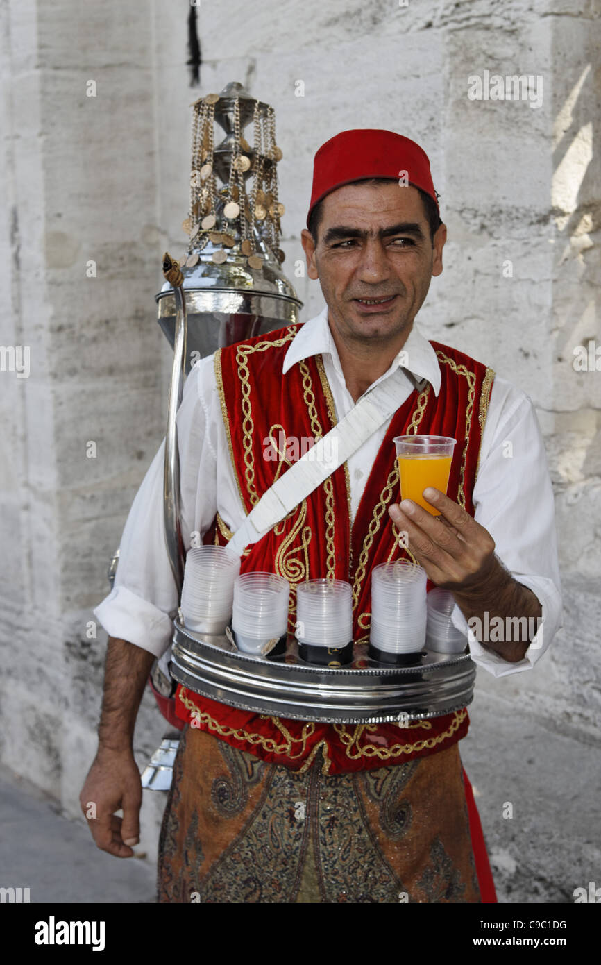 Uomo con tradional costum ottomano succo di vendita nella parte anteriore della moschea Sulemaniye, , Istanbul, Turchia , in Europa, Foto Stock