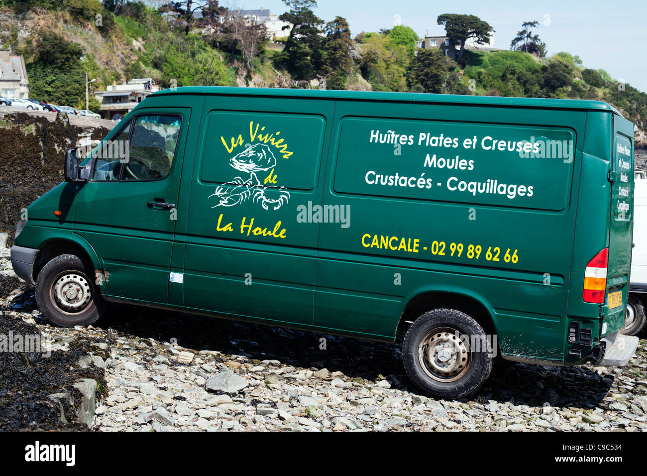 Ostriche e molluschi del concessionario veicolo parcheggiato sulla spiaggia pietrosa, Cancale, Brittany, Francia, Europa Foto Stock