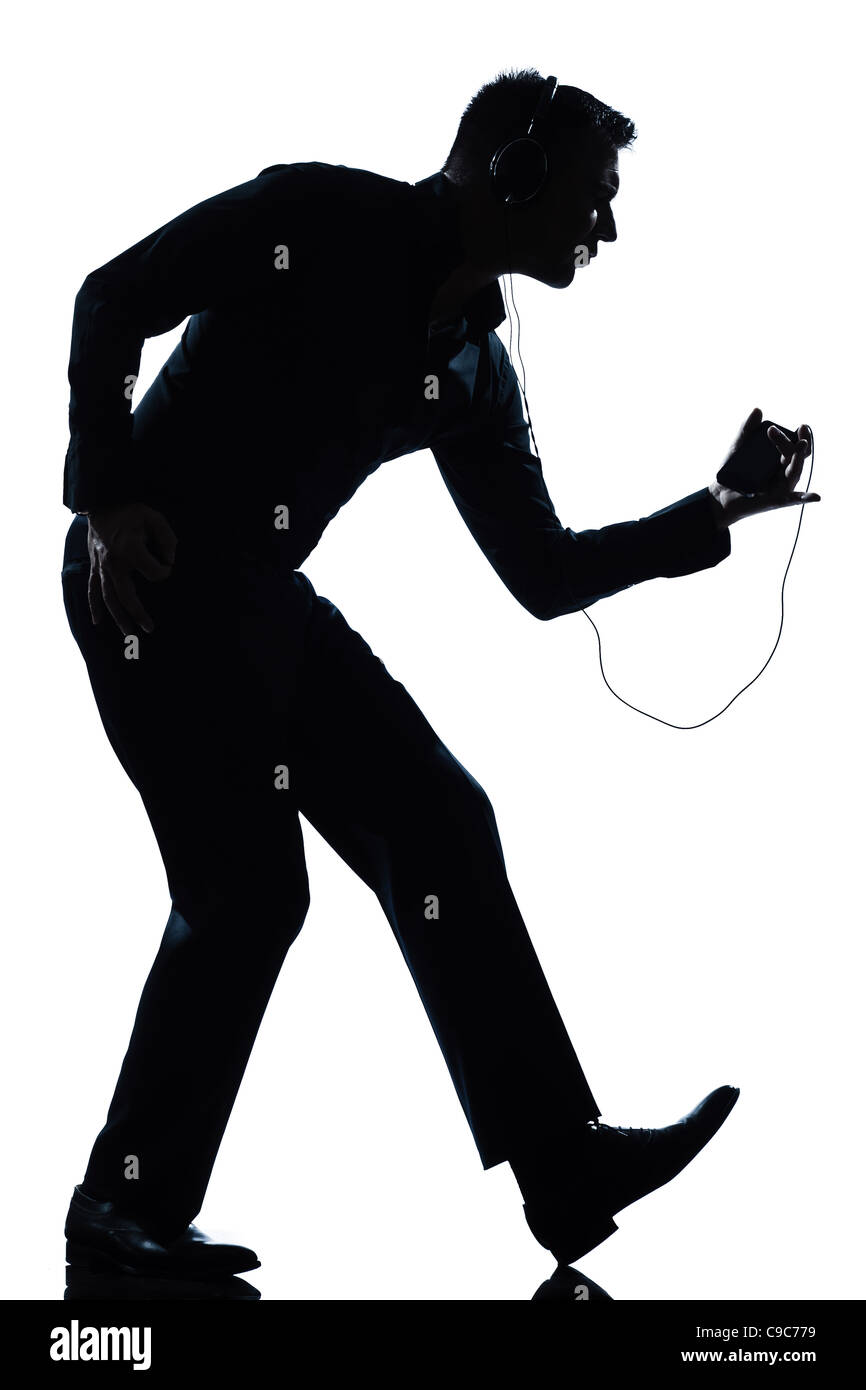 Un uomo felice ballare ascoltando la musica a piena lunghezza silhouette in studio isolato sfondo bianco Foto Stock