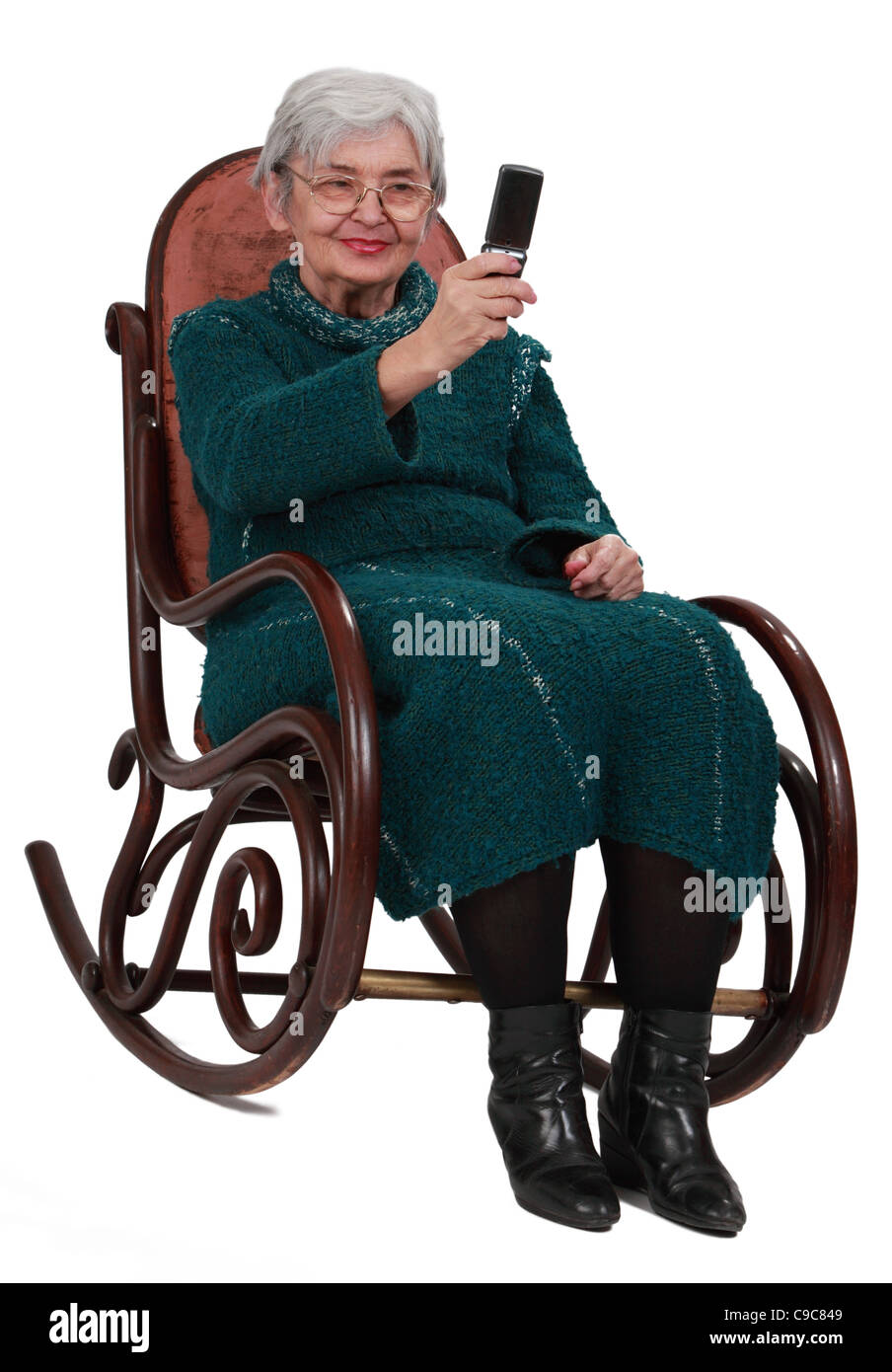Senior donna seduta in un bilanciere e scattare foto con un telefono cellulare. Foto Stock
