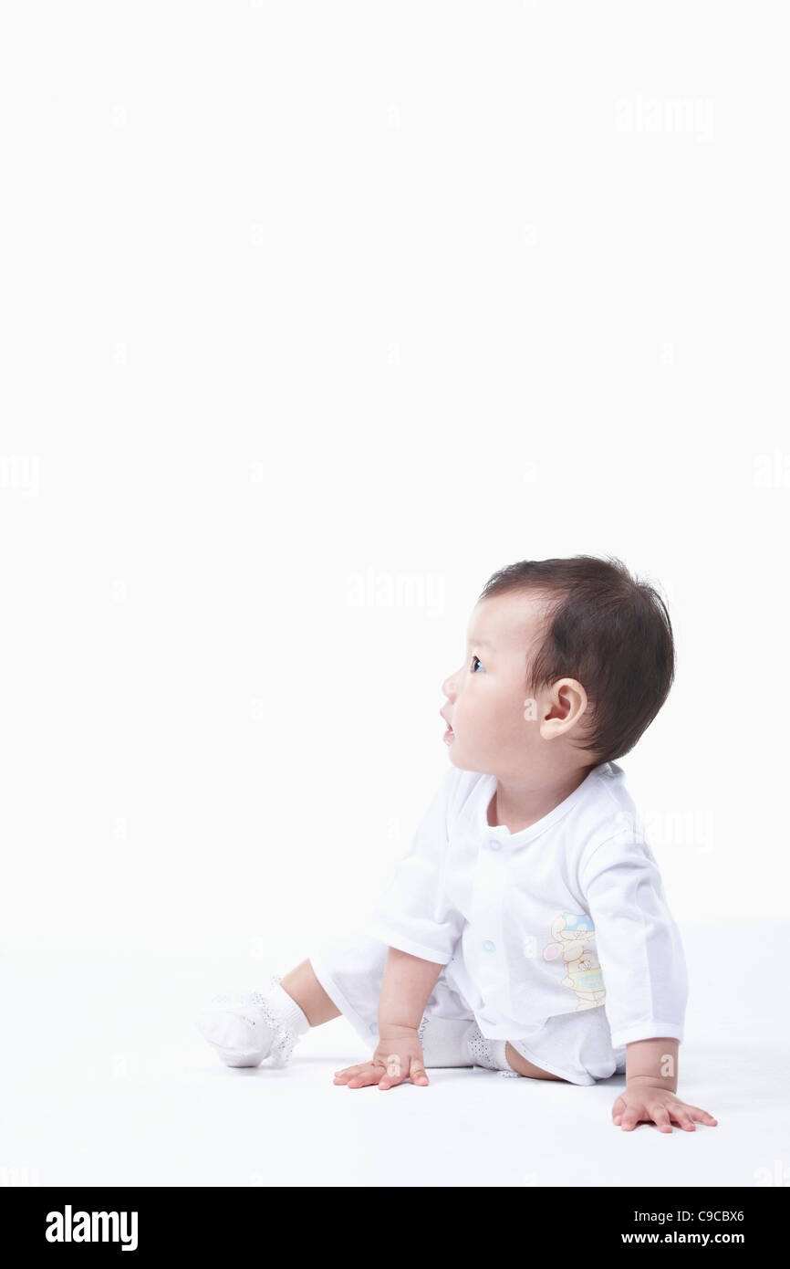Baby boy in bianche vesti Foto Stock