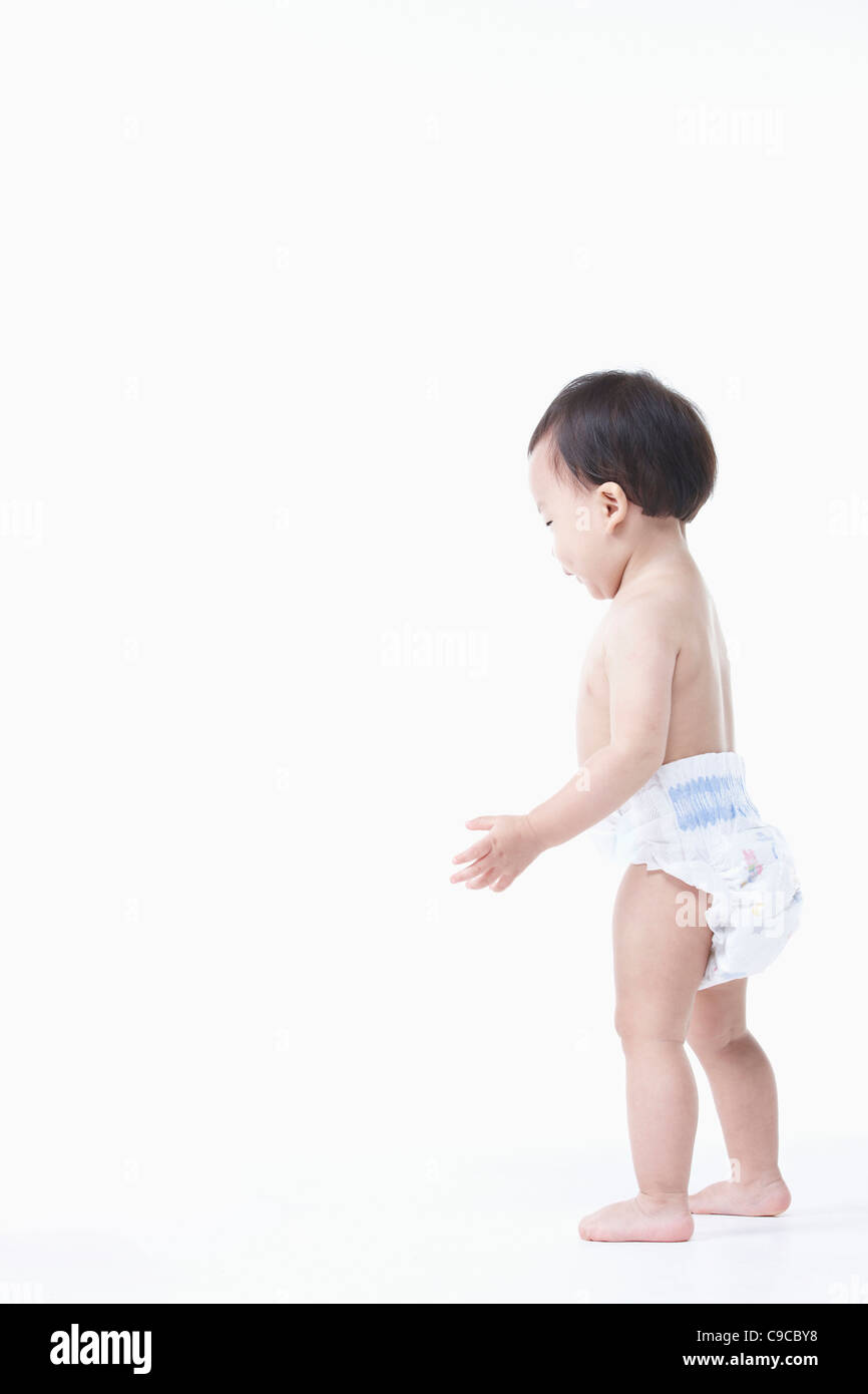 Baby boy nel pannolino in piedi Foto Stock