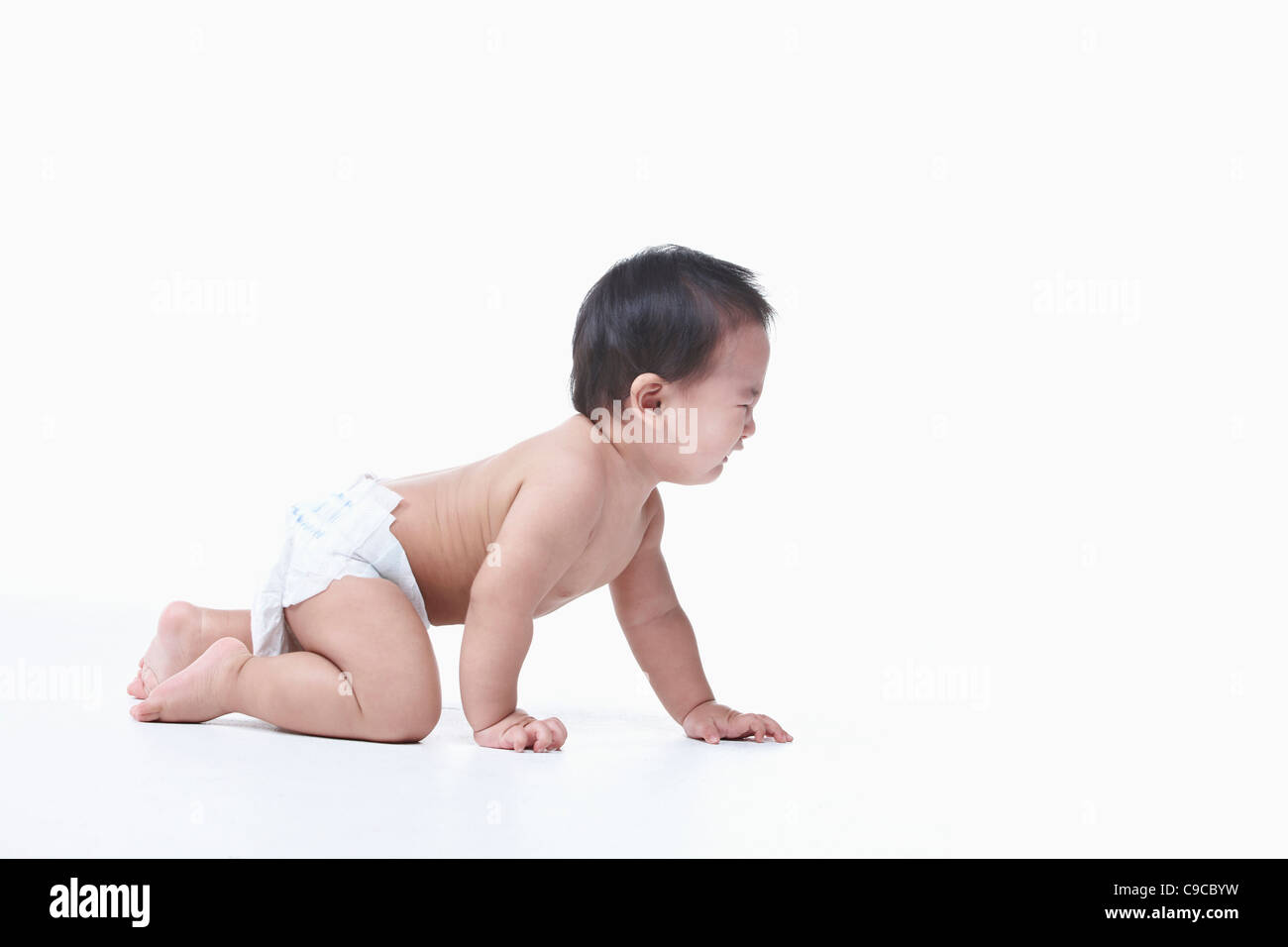 Baby boy nel pannolino gattona Foto Stock