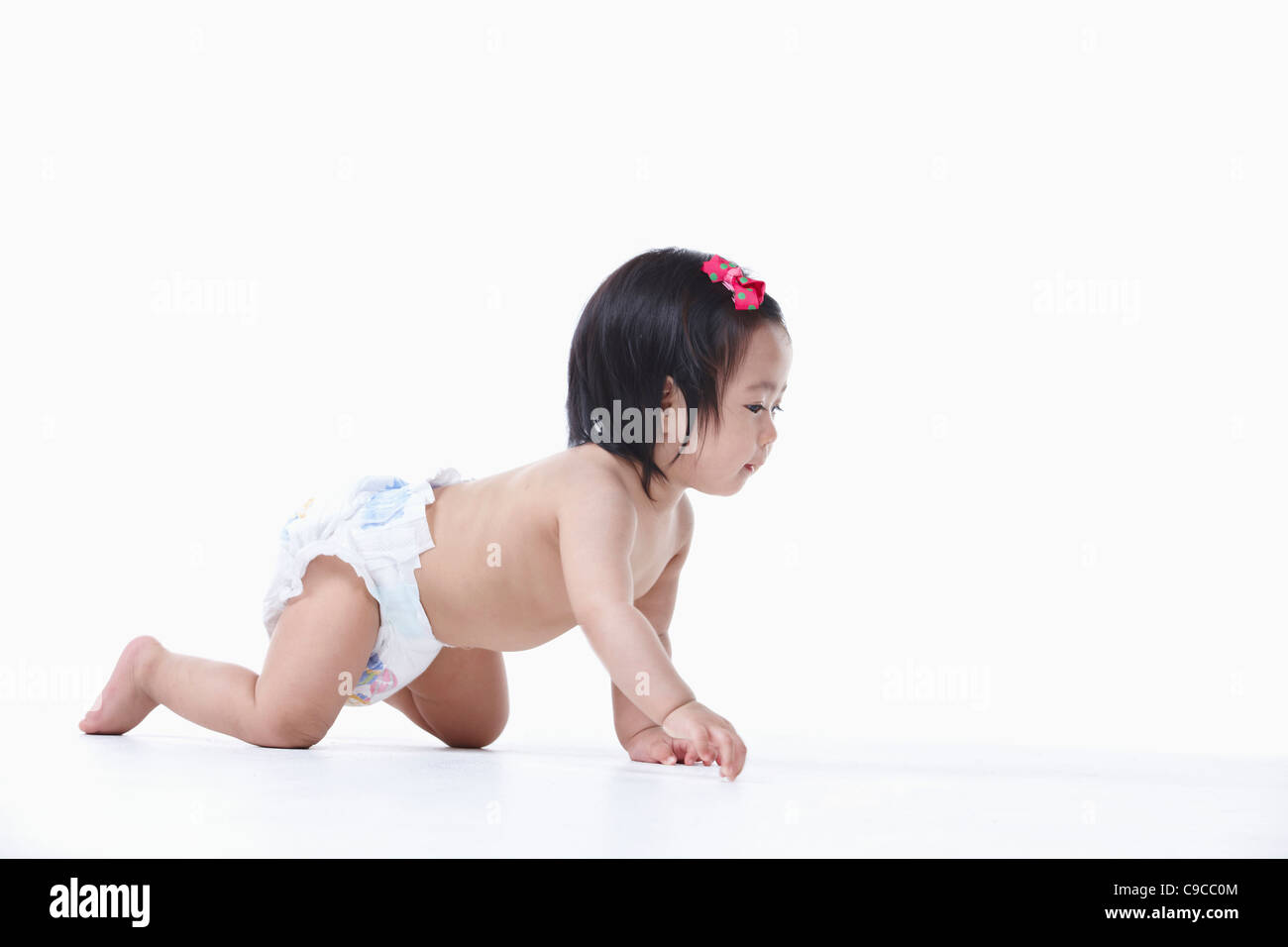 Baby girl nel pannolino gattona Foto Stock