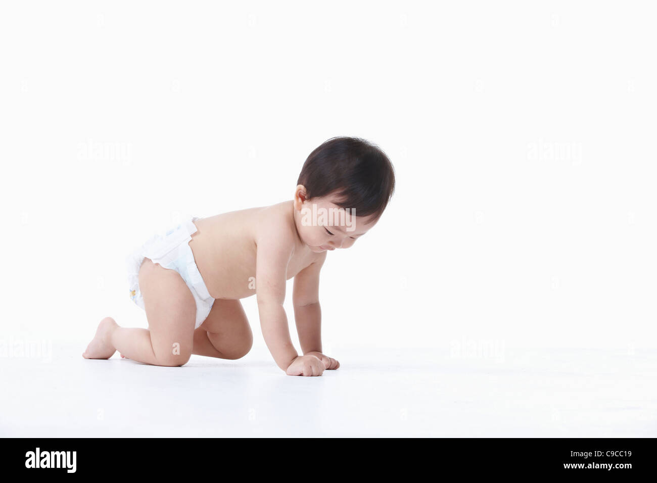 Baby boy nel pannolino gattona Foto Stock