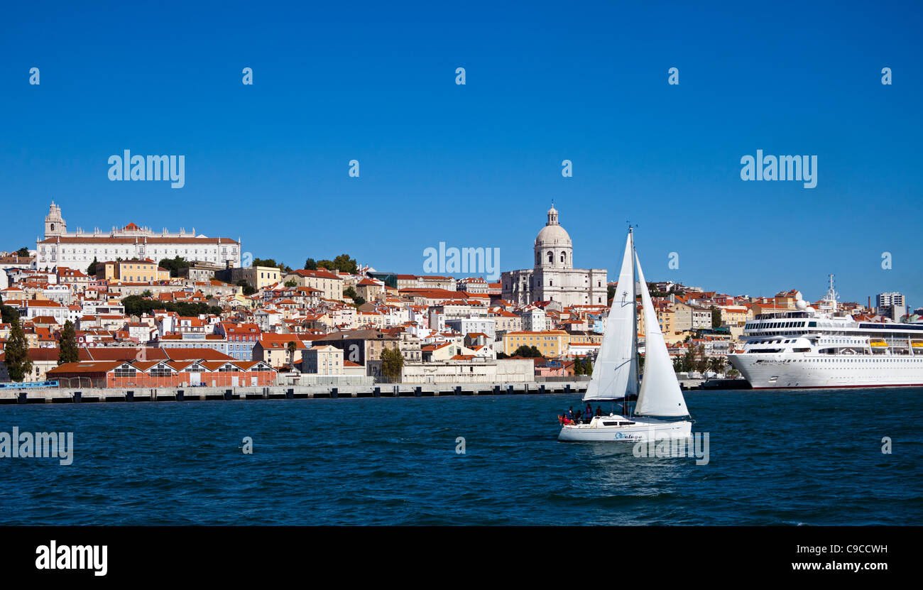 Barca a vela sul fiume Tago con il quartiere di Alfama in background Lisbona Portogallo Europa Foto Stock