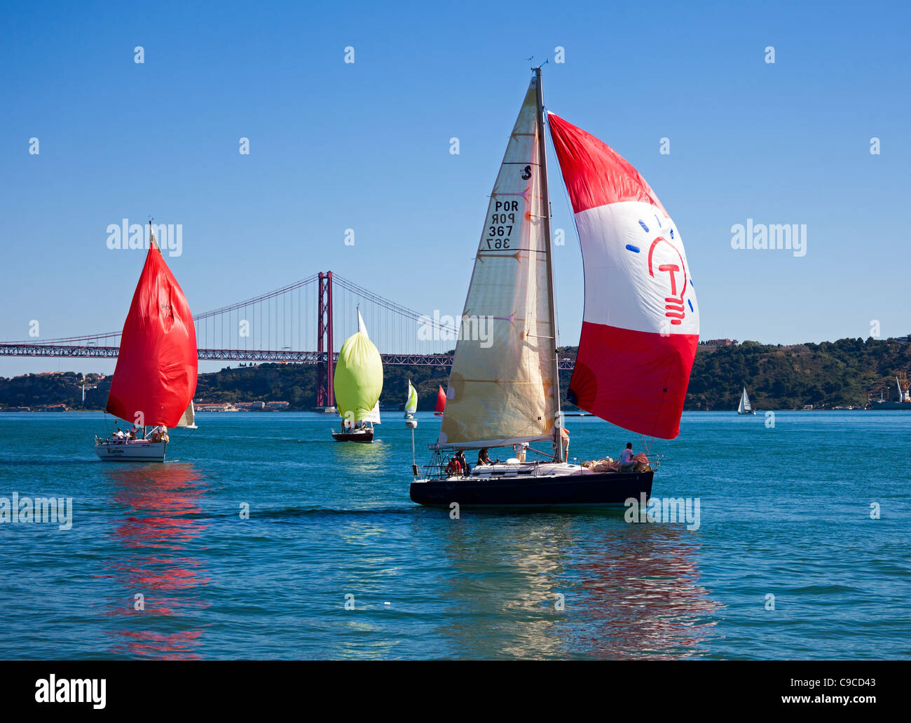 Barca a vela sul fiume Tago con il Ponte 25 de Abril Bridge in background Foto Stock