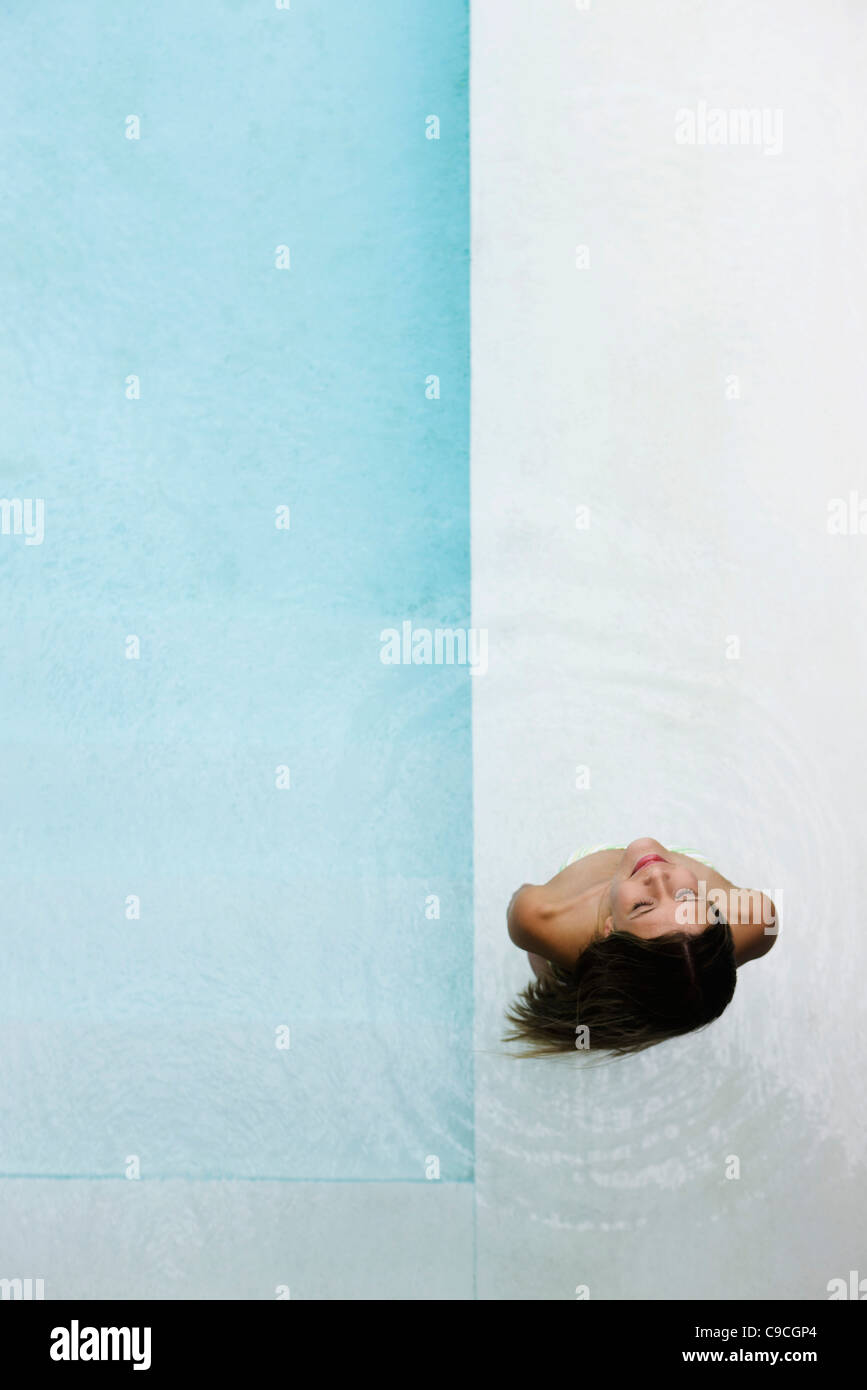 Donna in piscina per bambini con look di contentezza Foto Stock