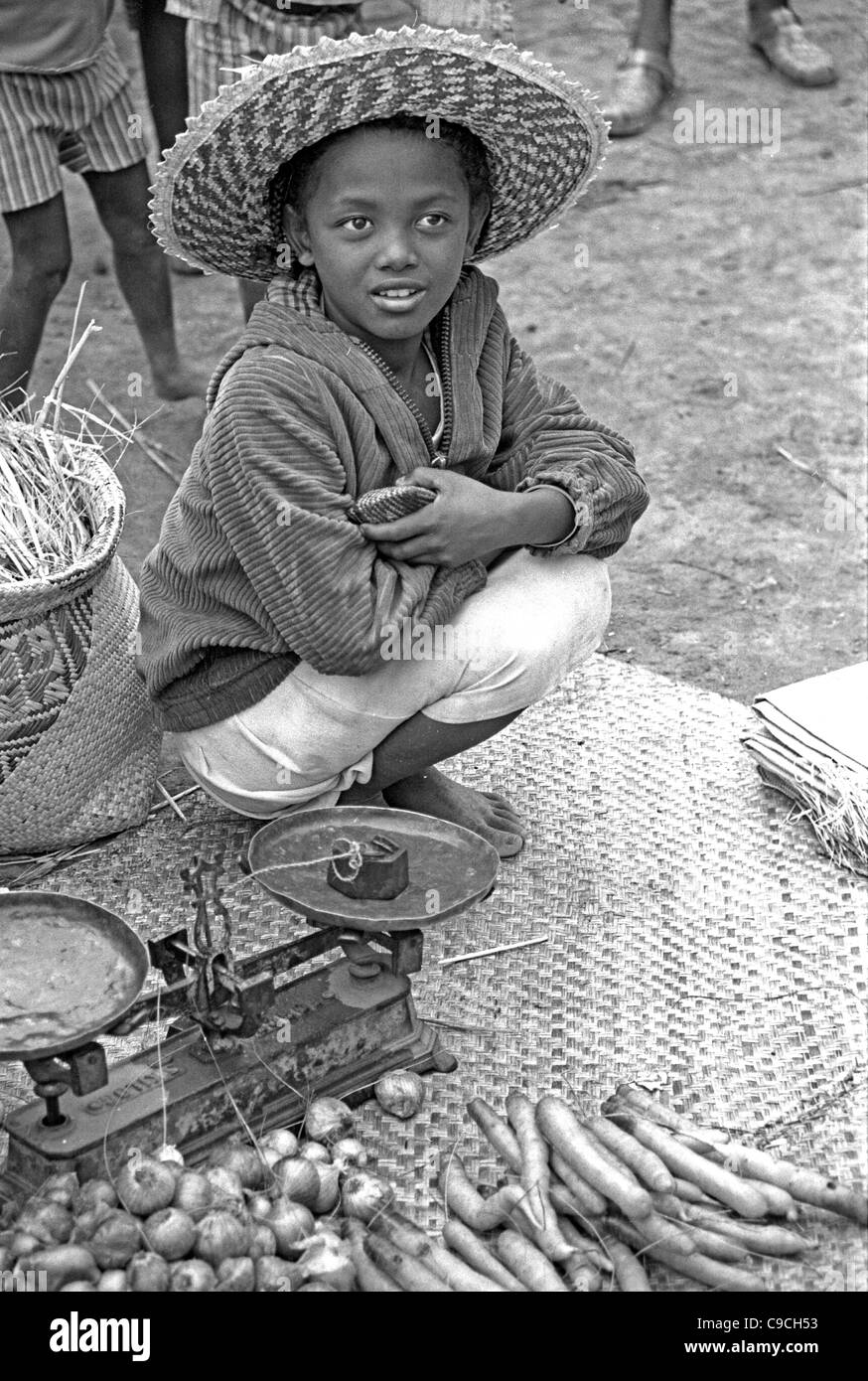 Giovane ragazza Betsileo o ragazza malgascia Vendita di verdure su un mercato in stallo, Ambalavao, Madagascar Foto Stock