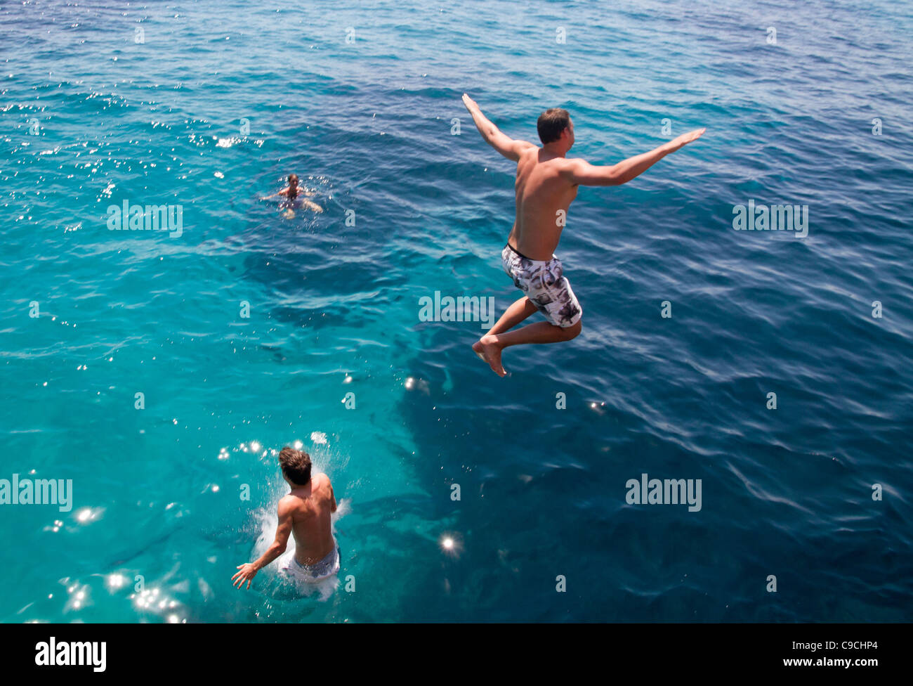 Giovane uomo saltare in acqua di mare Maiorca Baleari Spagna Foto Stock