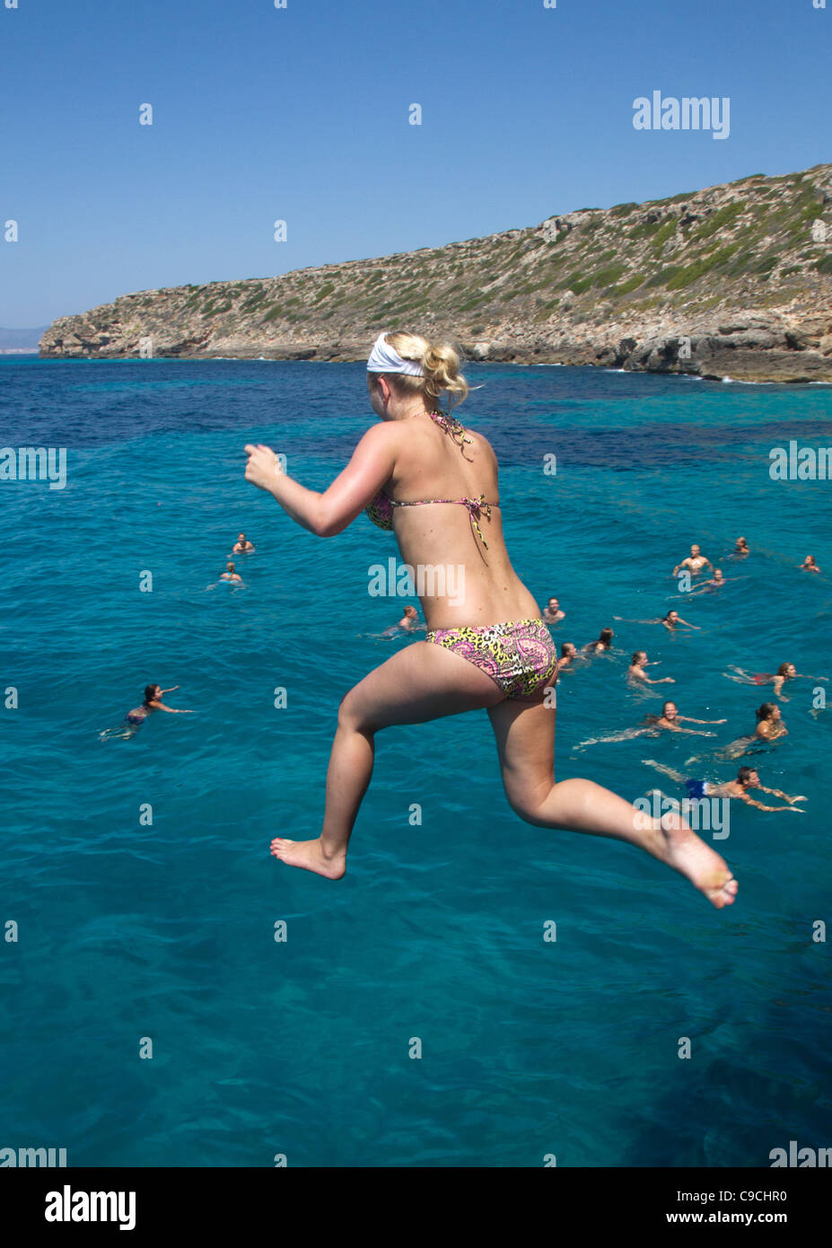 Giovane donna saltare in acqua di mare Maiorca Baleari Spagna Foto Stock
