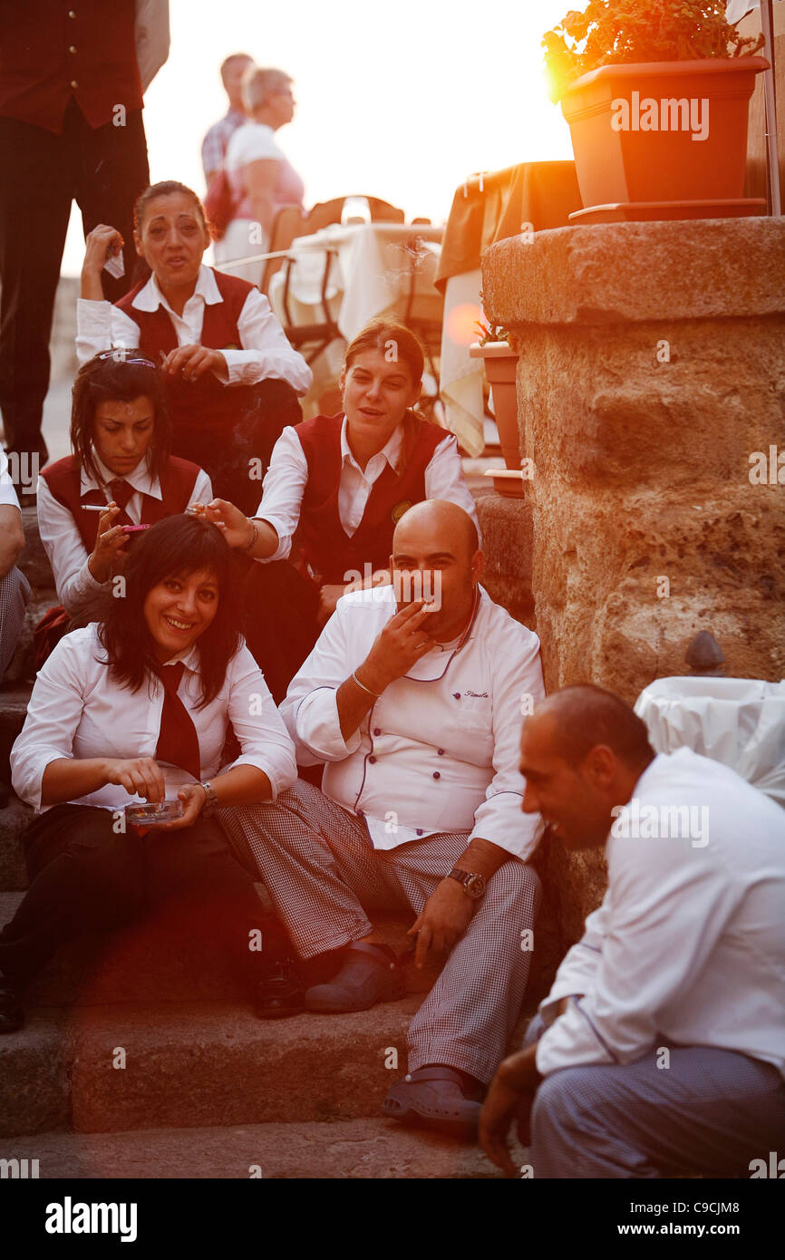 Il personale del ristorante nella città vecchia avente una pausa, Alghero, Sardegna, Italia. Foto Stock