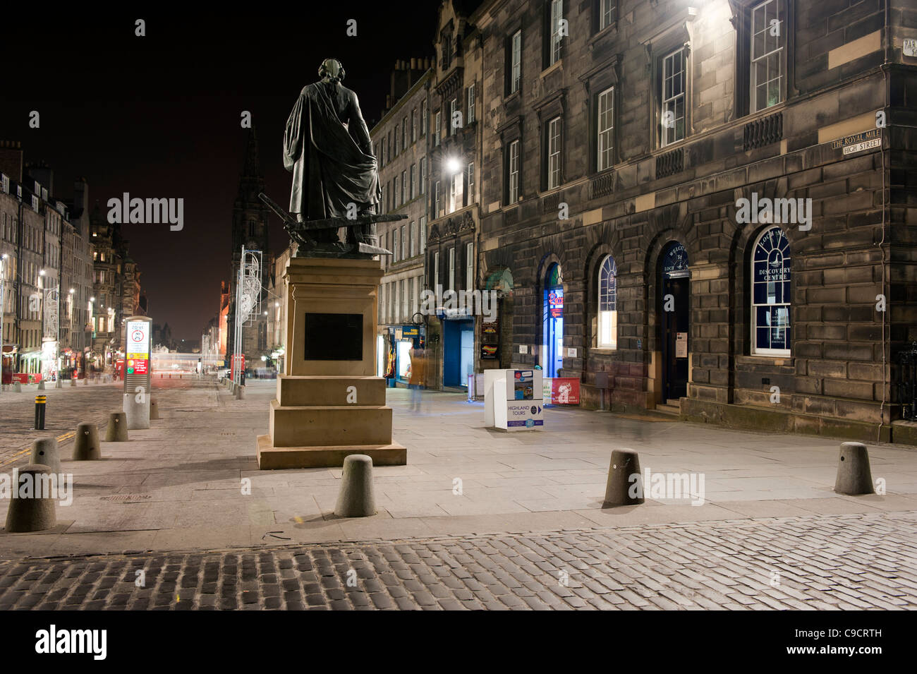 Vista del Royal Mile di Edimburgo scattata di notte con la Adam Smith statua in primo piano. Foto Stock