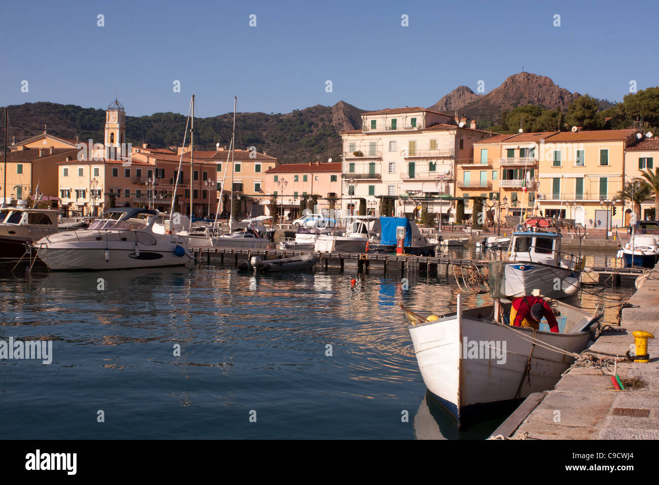 Viaggi, Italia - vecchio pescatore fishnets pulizia nella sua barca - Porto Azzurro, EBA ISOLA, Italia. Foto Stock