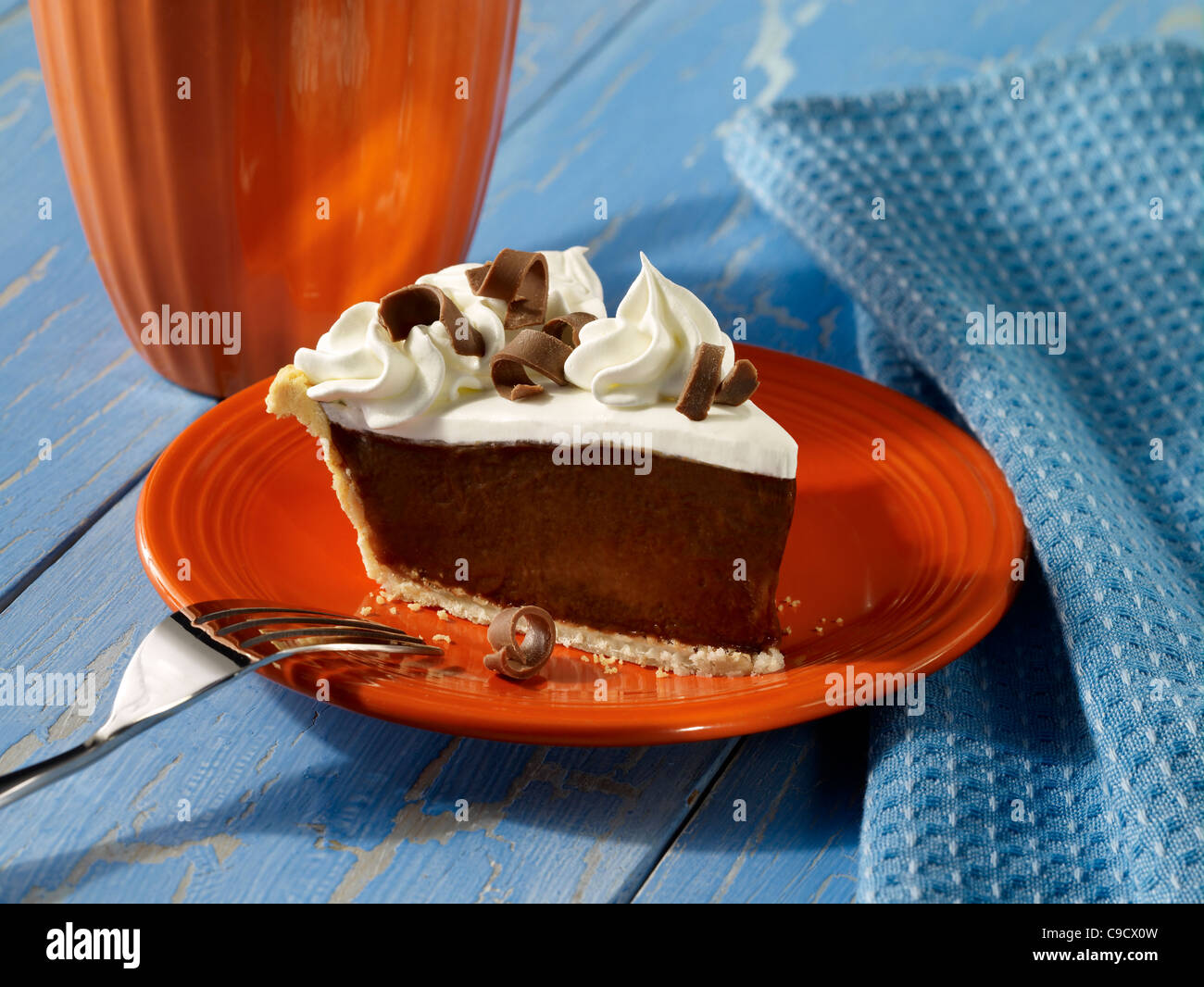 Una fetta di crema di cioccolato torta guarnita con panna montata e riccioli di cioccolato Foto Stock