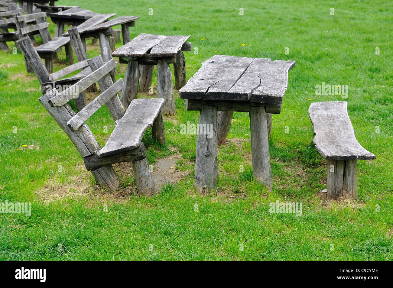 Vecchia panca di legno su erba verde in posizione di parcheggio Foto Stock