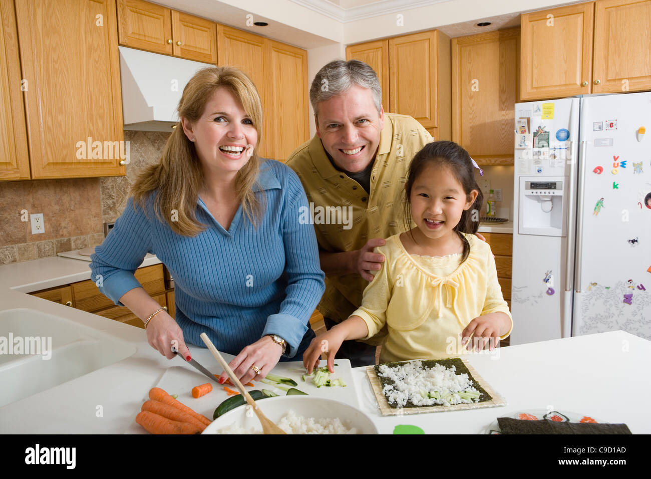Ritratto di una famiglia in cucina rendendo sushi Foto Stock
