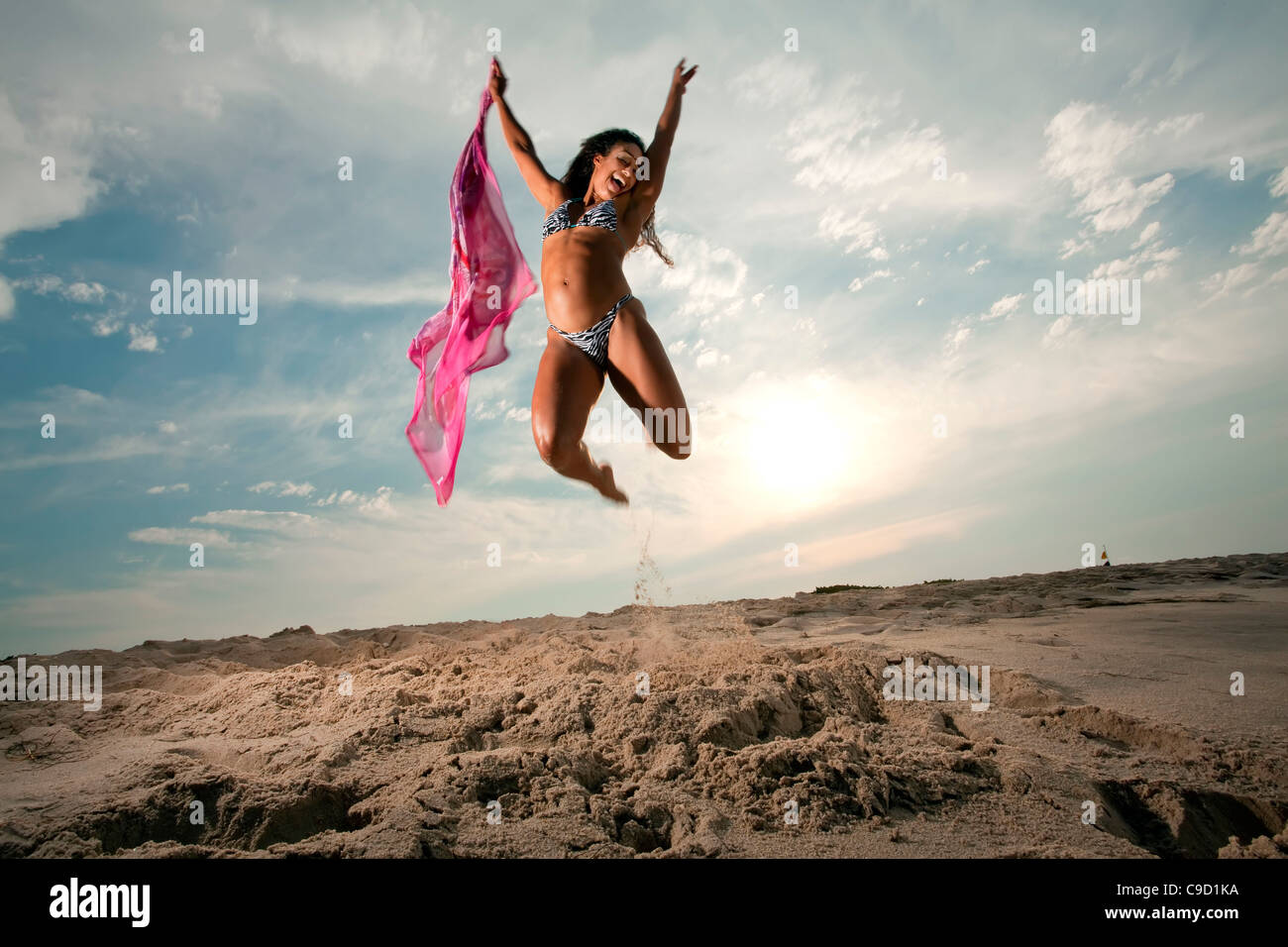 Stati Uniti d'America, Florida, Donna in bikini salto sulla spiaggia con sciarpa in mano Foto Stock