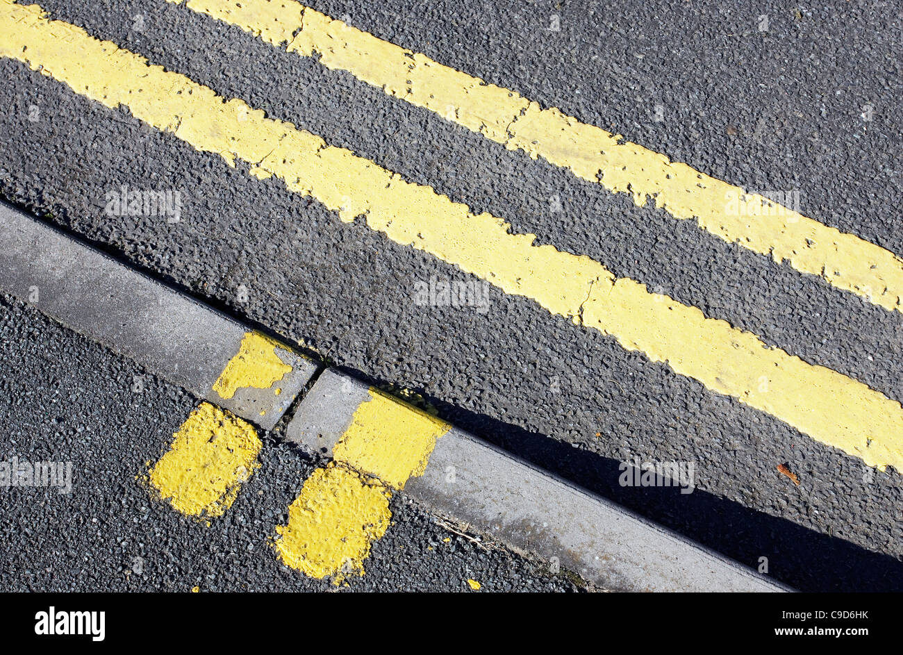 Doppio parcheggio giallo e il caricamento di marcature di restrizione dipinta su una strada e pavimentazione. Foto Stock