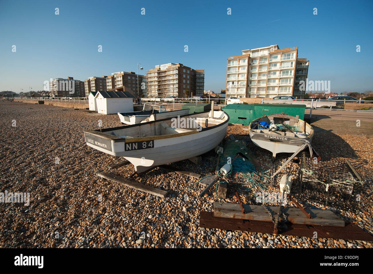 Lungomare e appartamenti a Bexhill on Sea, East Sussex, Inghilterra con spiaggiata barche da pesca Foto Stock
