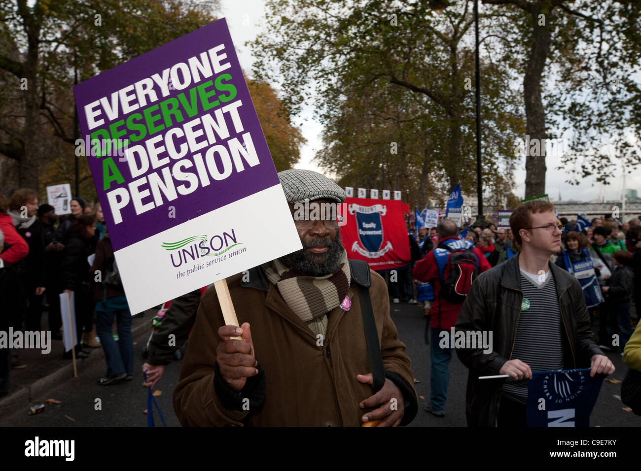 Londra, UK, 30/11/2011. Protester tenendo un unisono cartello con lo slogan "Ognuno merita una pensione decente' marciando a un rally a Victoria Embankment per mostrare la loro rabbia a pubiche e tagli di spesa. Foto Stock