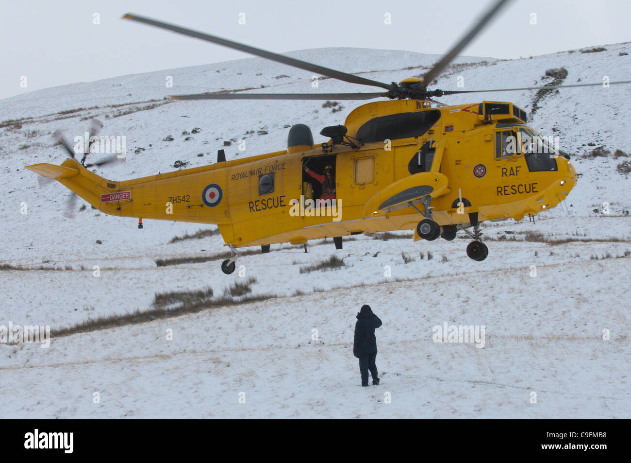 Un RAF Salvataggio in elicottero atterra a 'Storey braccio' - La prima neve arriva sul Parco Nazionale di Brecon Beacons, Wales, Regno Unito. Foto Stock