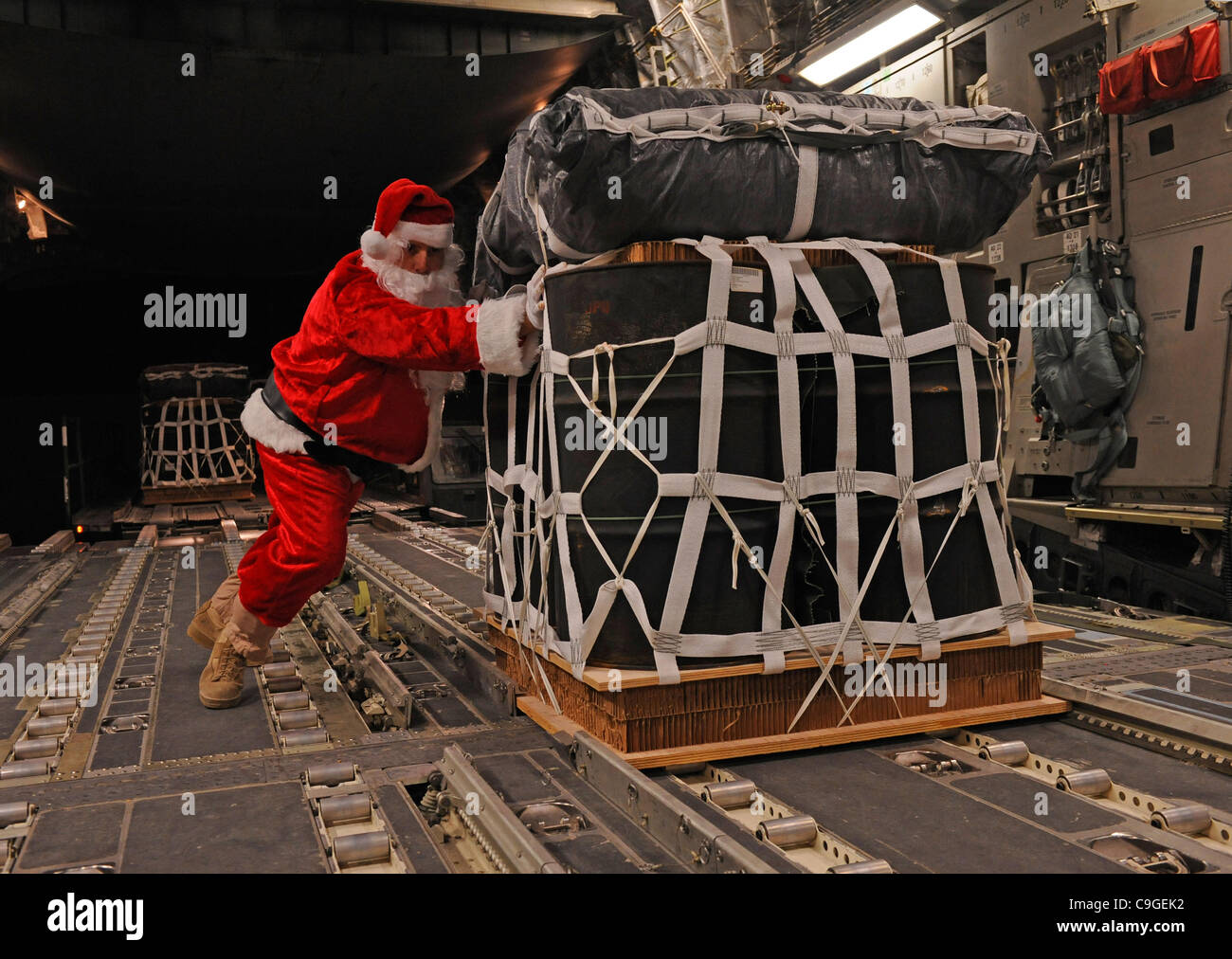 US Air Force Sgt. Mike Morris di Charleston, Sc vestiti da Babbo Natale carichi di un pallet su un C-17 aeromobile dic. 23, 2011 in Afghanistan. Le palette sono state catapultato al remote in avanti le basi operative in Afghanistan. Foto Stock