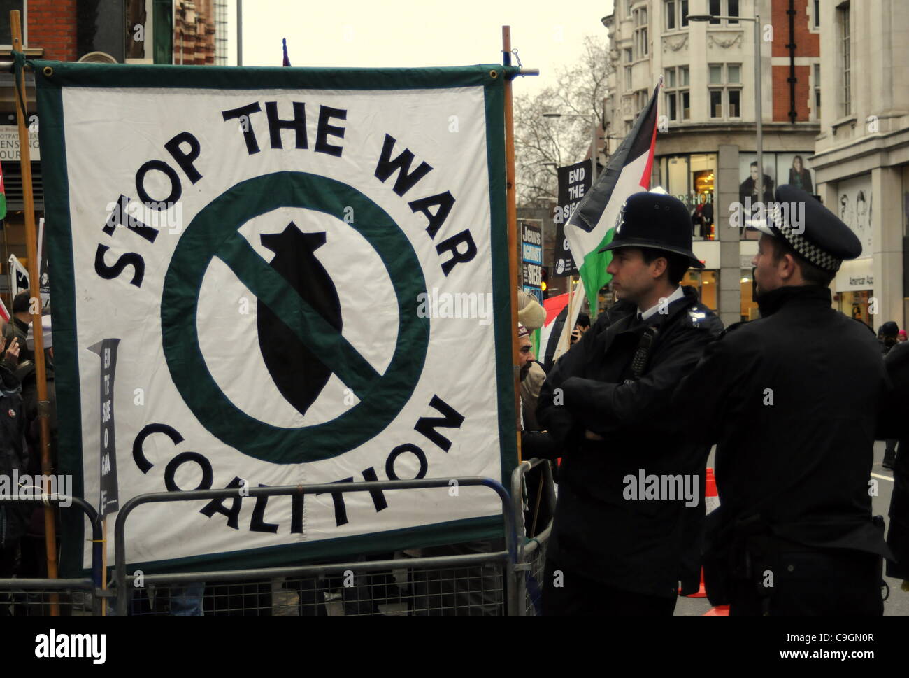 Gli ufficiali di polizia guardare un banner durante la fase di sosta della coalizione bellica la dimostrazione al di fuori dell'Ambasciata israeliana a Londra. 27/12/11 Foto Stock