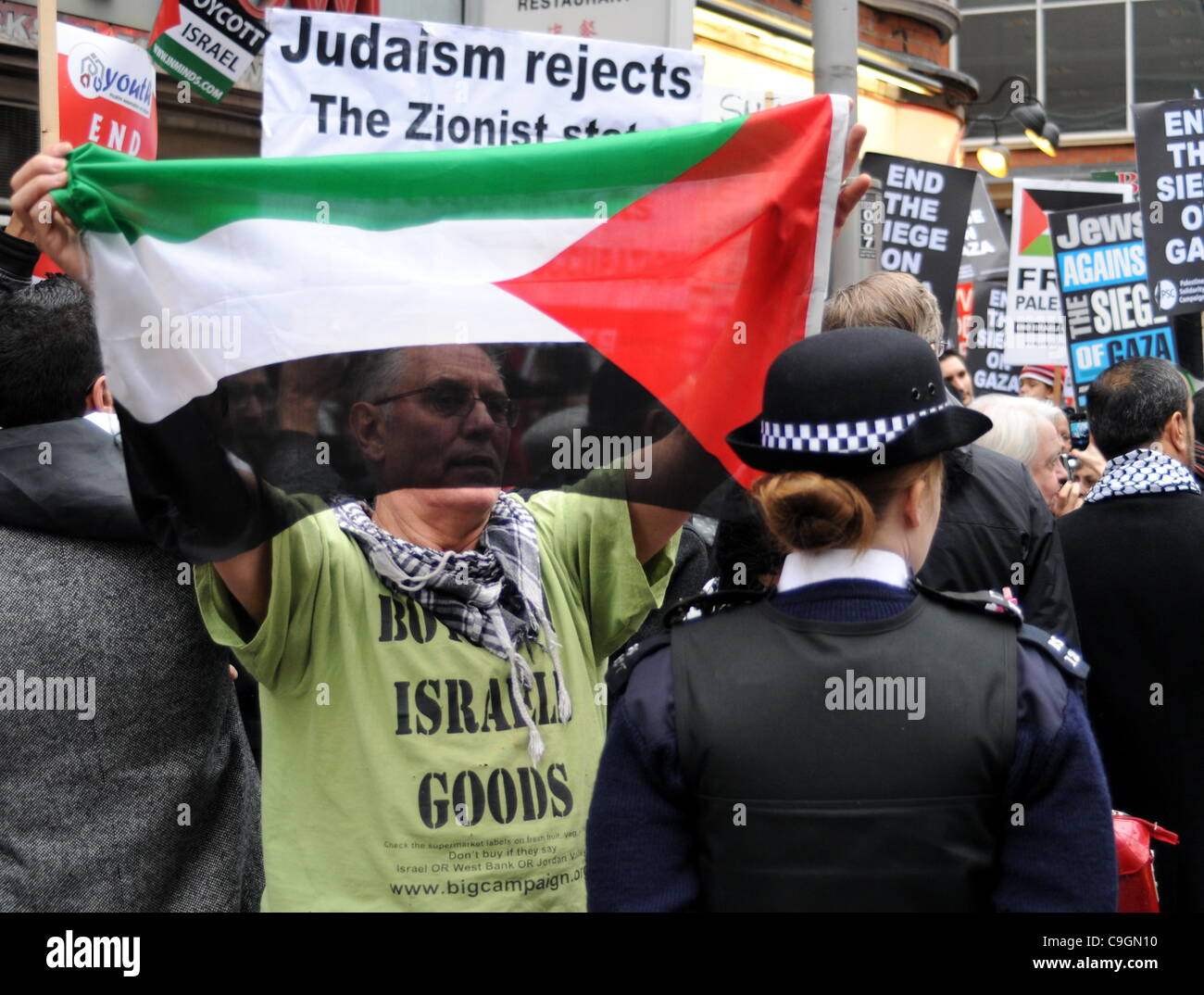 Protester contiene fino a bandiera palestinese a una WPC durante la fase di sosta della coalizione bellica la dimostrazione al di fuori dell'Ambasciata israeliana a Londra. 27/12/11 Foto Stock