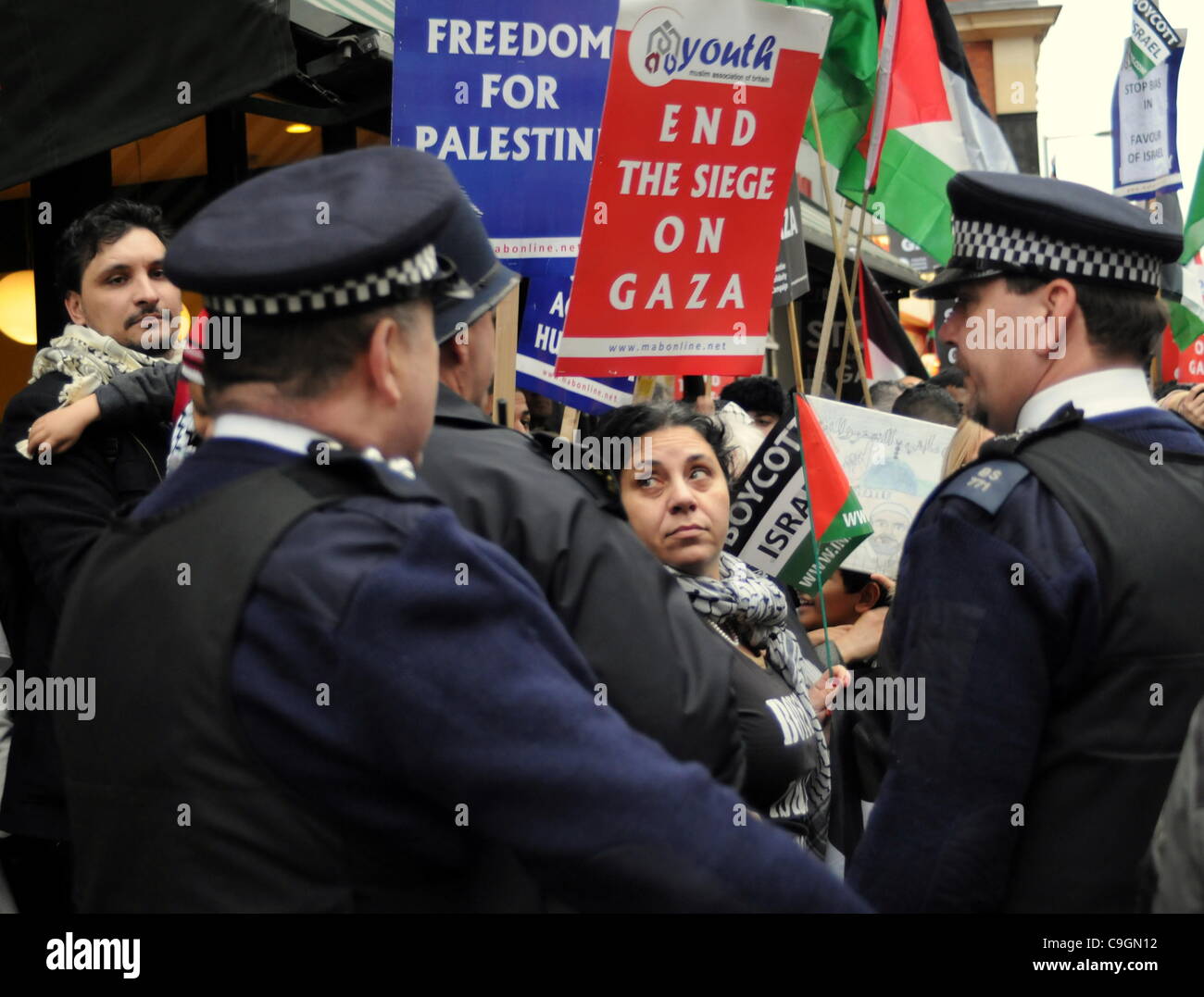 La polizia contengono i manifestanti durante la fase di sosta della coalizione bellica la dimostrazione al di fuori dell'Ambasciata israeliana a Londra. 27/12/11 Foto Stock