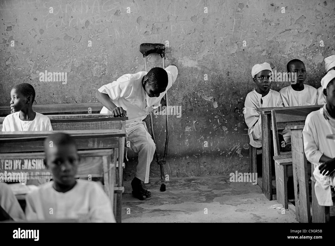 Sett. 27, 2010 - Kano, Kano, NIGERIA - Abdullahi Alasan, 18, è stata paralizzata con la polio per molti anni e non è stata in grado di permettersi la scuola fino ad ora. Il governo nigeriano permette agli studenti con la polio ad andare a scuola per la libera e lui è in una classe con 6-10 anni in una scuola primaria di Kano, N Foto Stock