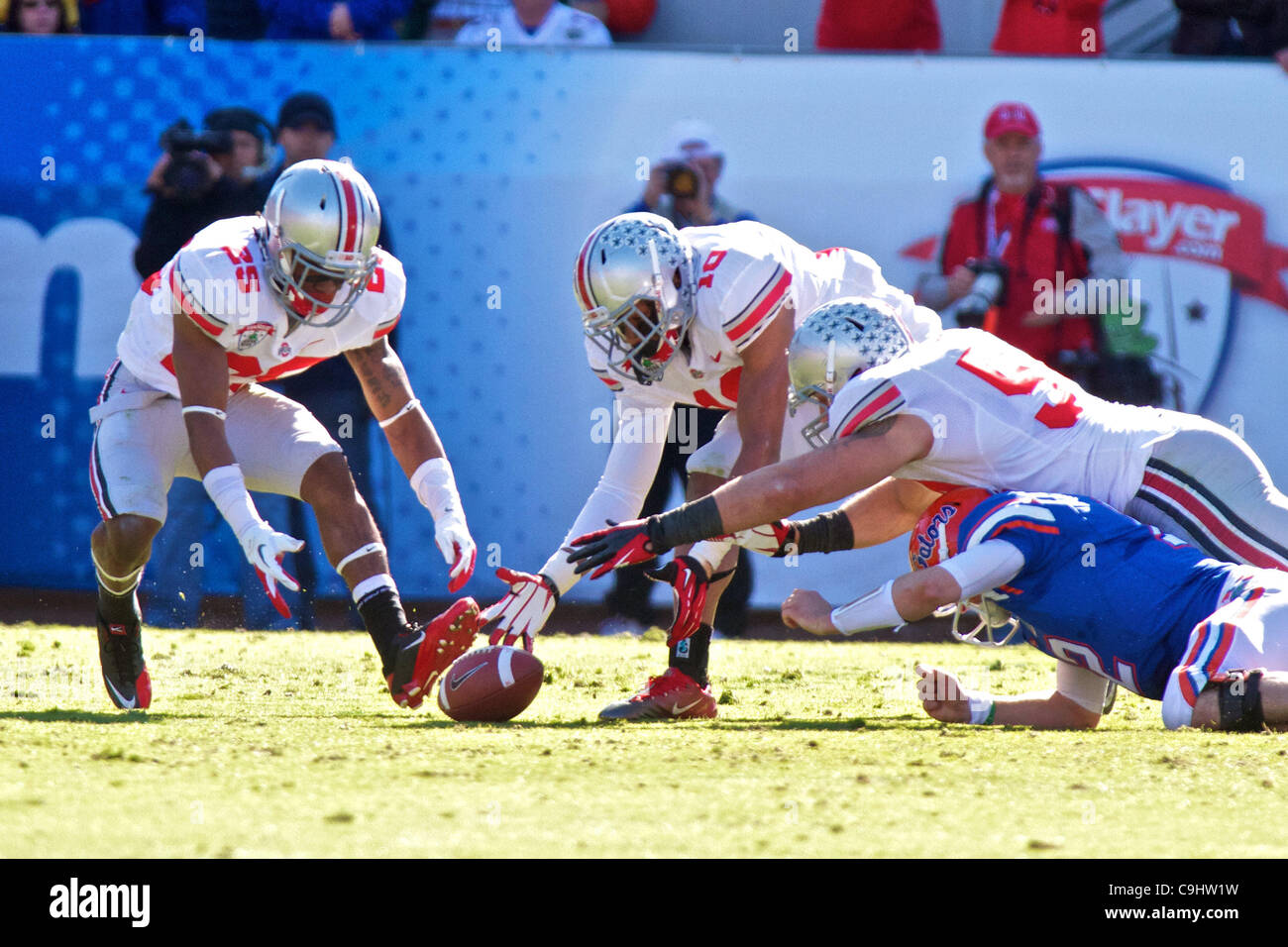 Gen 2, 2012 - Jacksonville, Florida, Stati Uniti - Ohio State Buckeyes defensive back Bradley Roby (25), Buckeyes linebacker Ryan Shazier (10) e difensivo Buckeyes affrontare John Simon (54) andare per la sfera allentati durante il primo trimestre del gioco tra Ohio State e Florida in il Gator Bowl a Everban Foto Stock