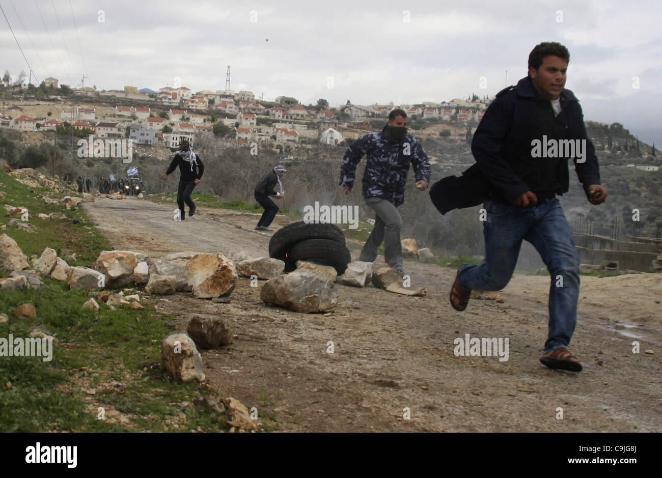 Gen 13, 2012 - Nablus, West Bank, Territori palestinesi - palestinesi scappare dai gas lacrimogeni sparati dalle forze di sicurezza israeliane durante una manifestazione di protesta nel villaggio di Kufr Qaddum vicino all'insediamento israeliano di Kdumim, nel nord della Cisgiordania, Venerdì , 13 gennaio, 2012. Foto di Wagdi Eshtayah (credito mi Foto Stock