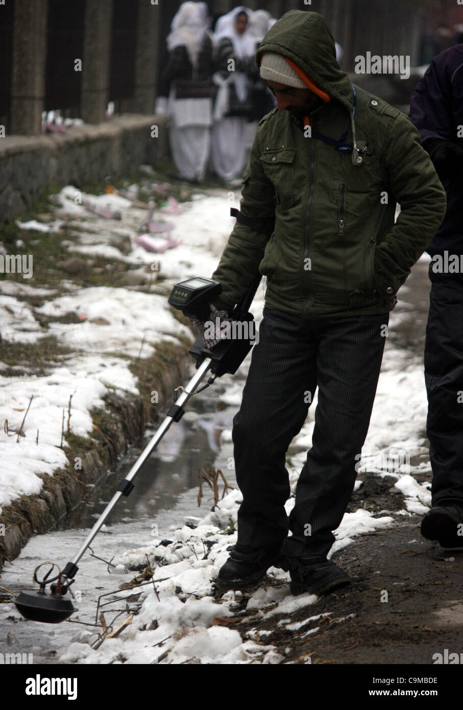 Ndian poliziotto searche per miniere e ied con i rivelatori di metallo al di fuori Bakhshi Stadium, il luogo di ritrovo principale per l'India celebrazioni del Giorno dell'indipendenza in Srinagar,la capitale estiva del Kashmir, India, 24 gennaio 2012. La sicurezza è stata potenziata in insurrezione-ha colpito stato di Jammu e Kashmir davanti a Foto Stock