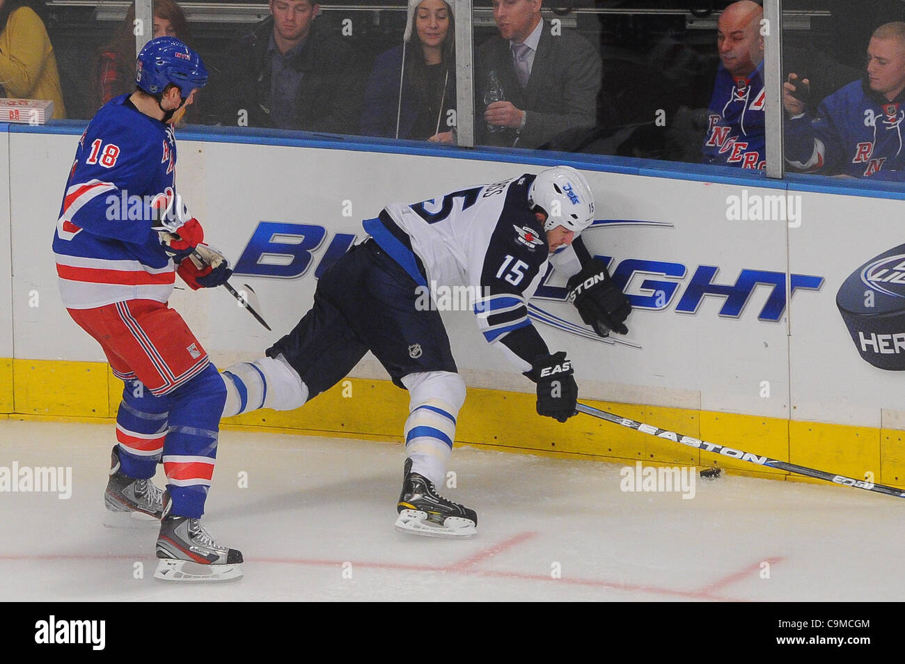 Gen 24, 2012 - Newark, New Jersey, Stati Uniti - New York Rangers defenceman Marc Staal (18) controlli di getti di Winnipeg ala sinistra Tanner vetro (15) nei pannelli durante il secondo periodo di azione di NHL tra i getti di Winnipeg e il New York Rangers al Madison Square Garden di New York, N.Y. I Rangers portano la J Foto Stock