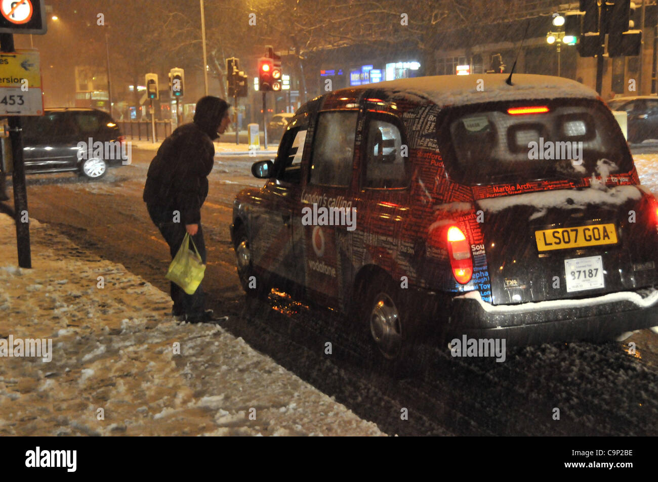 La neve cade su Londra Sabato notte. Salutando un Black Cab vicino a Baker Street Station come più di due centimetri di neve cade. Foto Stock