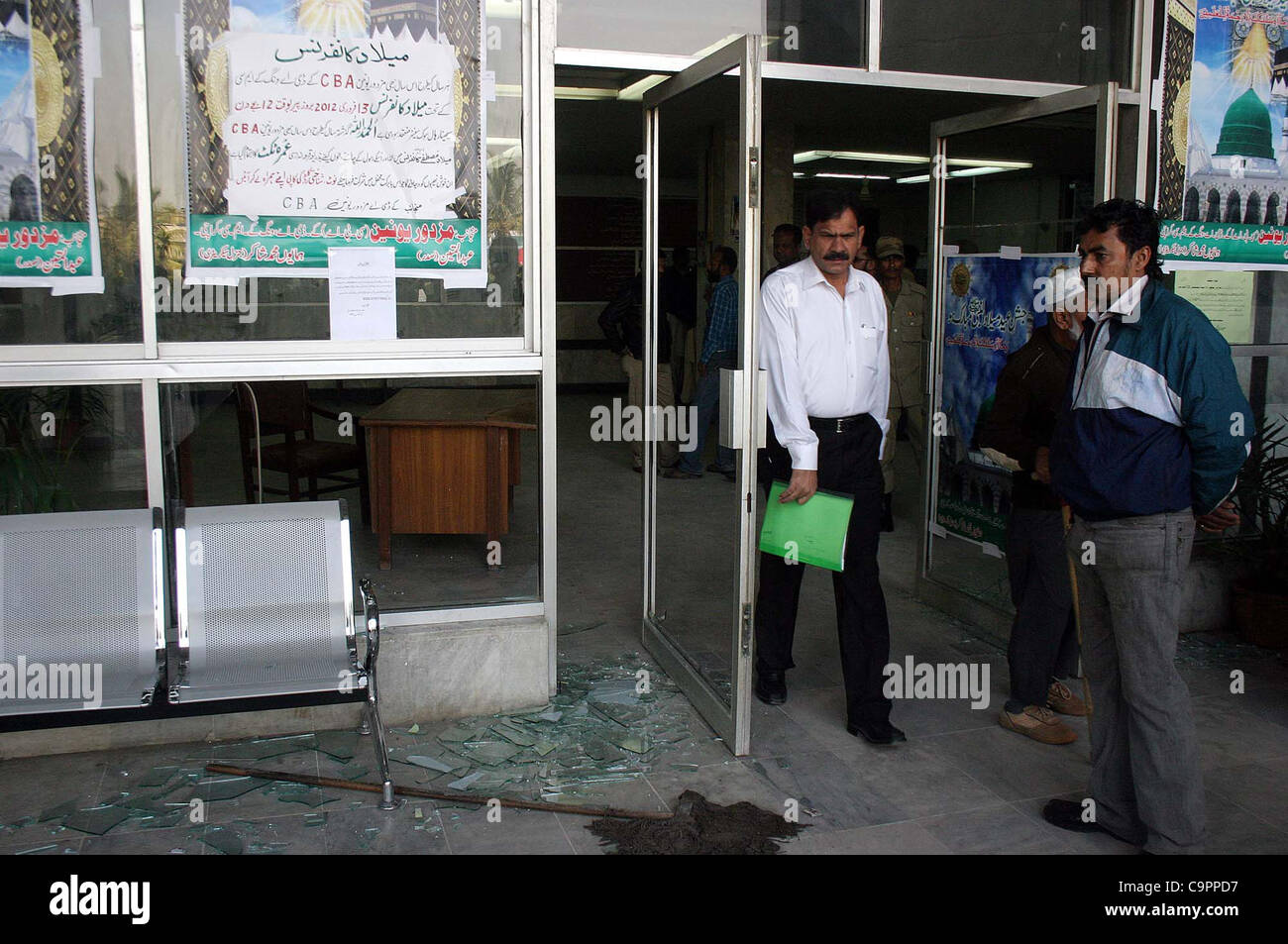 Un uomo guarda distrutto vetri come manifestanti arrabbiati sono state scagliate pietre presso il Centro Civico durante la manifestazione di protesta di medici e di personale paramedico in favore delle loro esigenze in Karachi giovedì 09 febbraio, 2012. Foto Stock