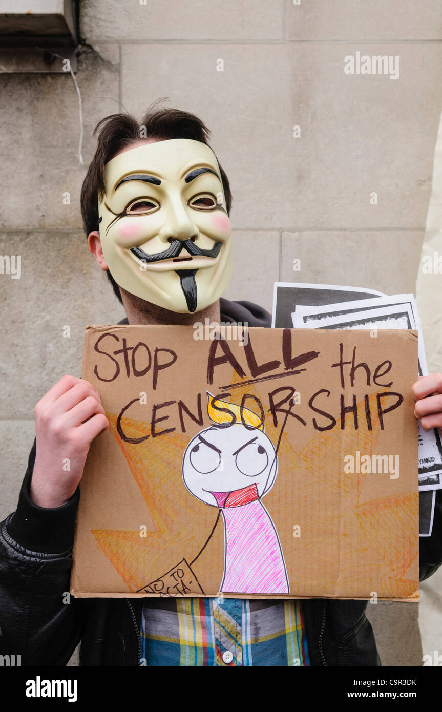 Membro dal gruppo di hacker 'Anonimo' indossando un 'V per Vendetta maschera" può contenere fino a casa poster chiamando per 'Stop tutti la censura' Foto Stock