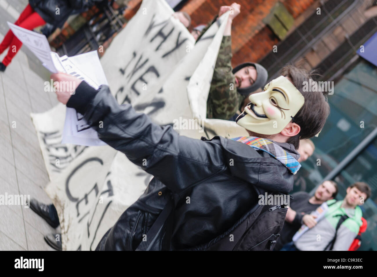 "Anonymnous' stati indossando un 'V per Vendetta" Maschera mani volantini per passare i membri del pubblico durante una manifestazione di protesta Foto Stock
