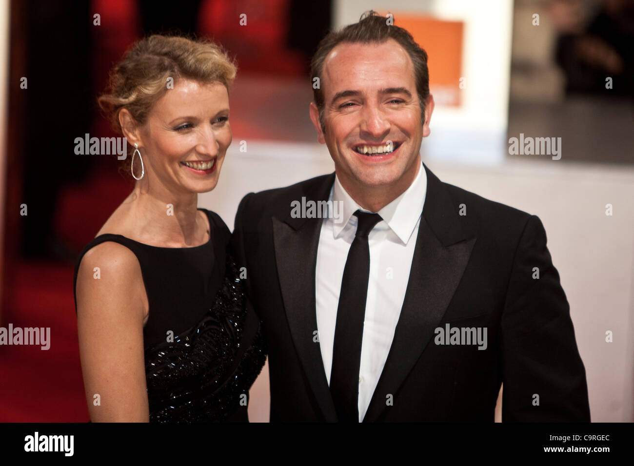Londra, UK, 12/02/2012. Attore francese Jean Dujardin) e sua moglie, l'attrice francese Alexandra Lamy, arrivando a lui 2012 BAFTAs Foto Stock