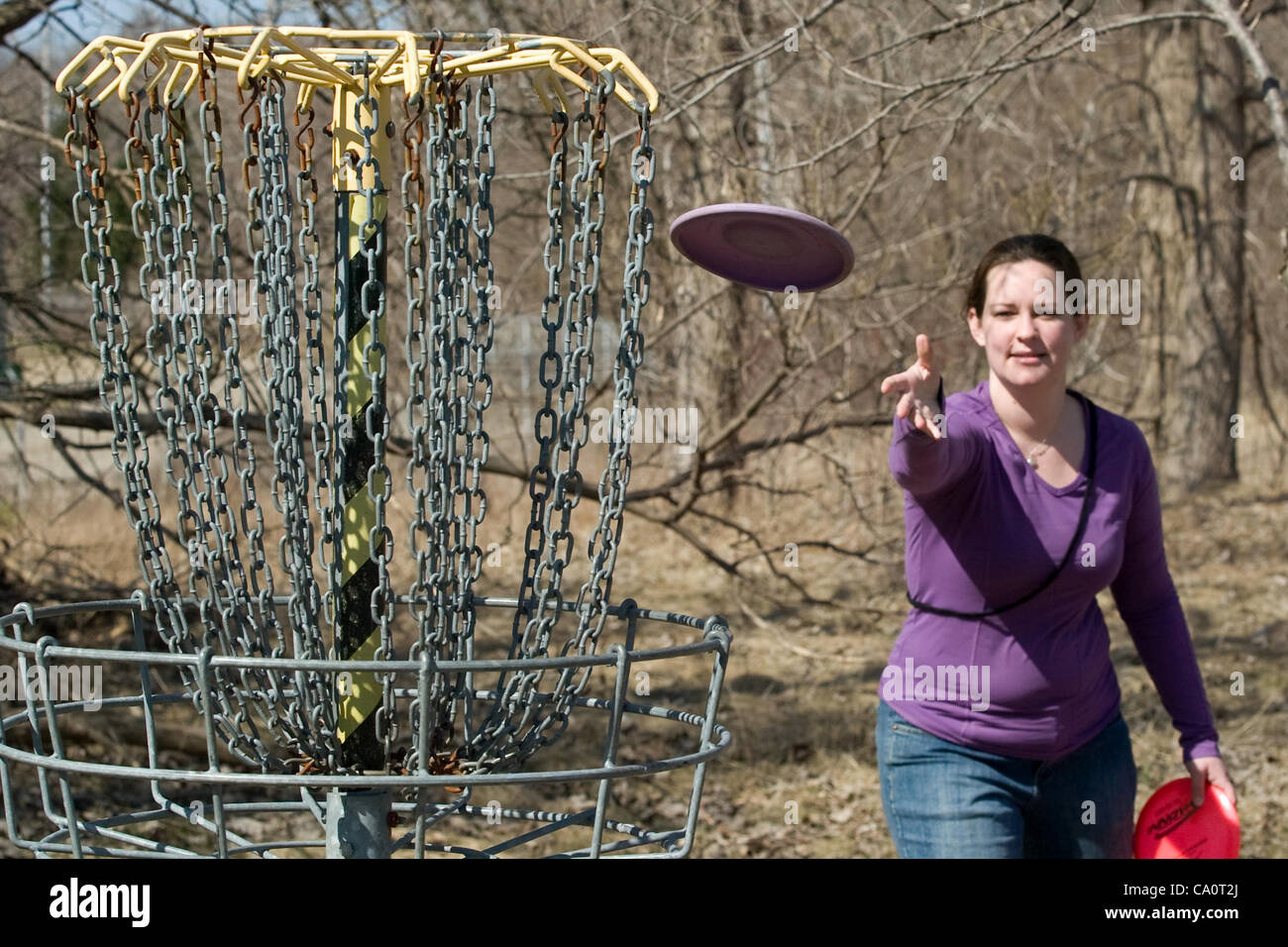 London Ontario, Canada - 14 Marzo 2012. Meg Jarvis fa un "Putt" durante una partita di Disc Golf a 18 Disc Golf Course si trova in St. Julien Park nella zona est di Londra. Londra si ha sia il campo da golf e un campionato che compete durante i mesi più caldi ogni sabato mattina. Le regole sono simili a t Foto Stock