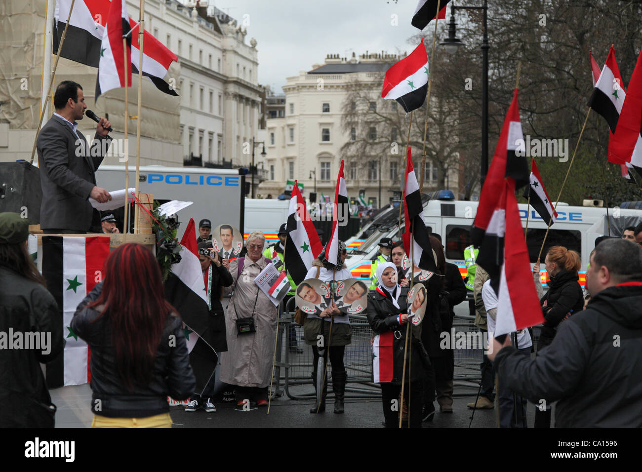 Londra, UK, 17 marzo 2012. Pro Assad dimostranti sventolare la bandiera nazionale e per il canto di slogan mentre l'anti Assad dimostrazione può essere visto in background. Foto Stock