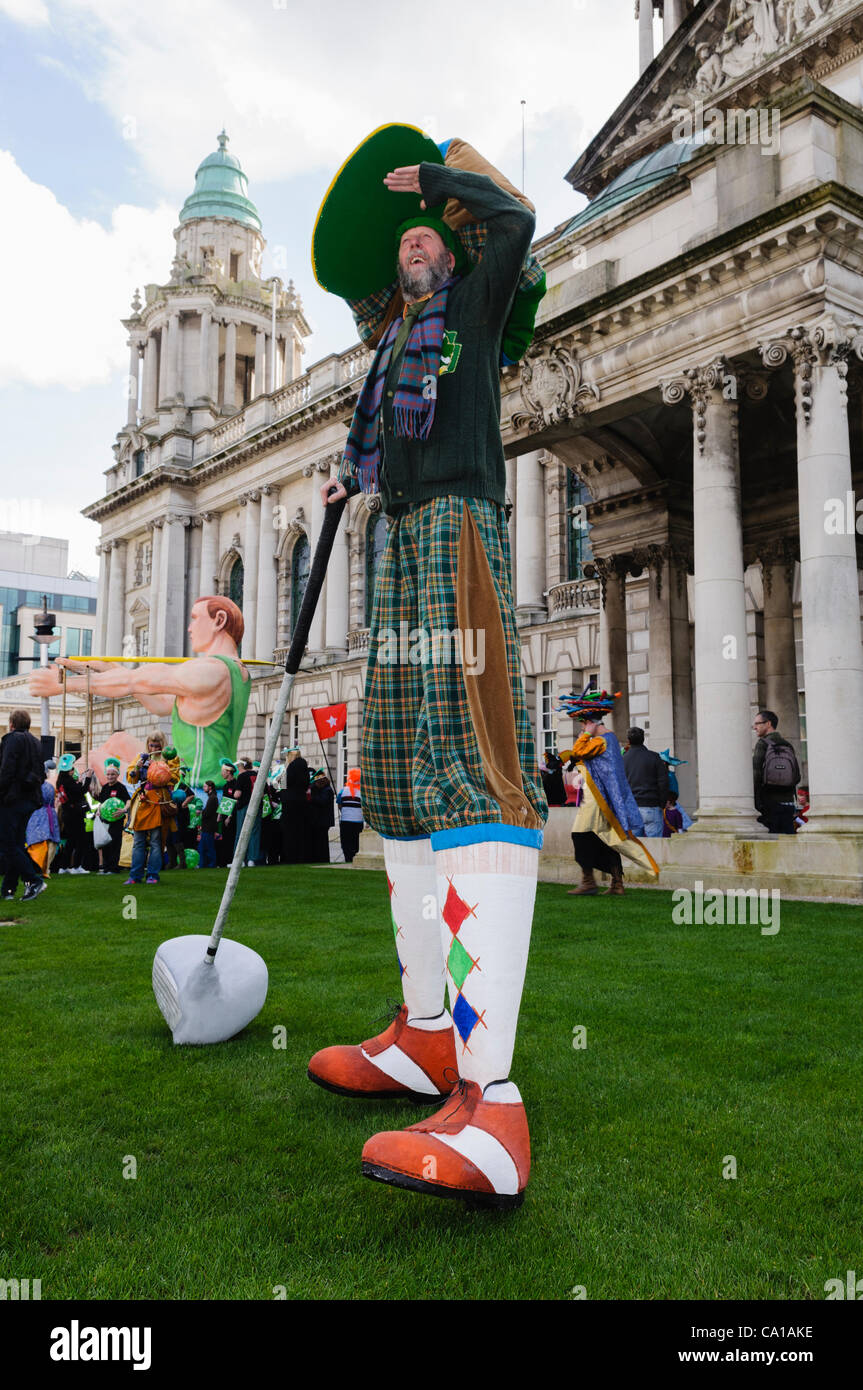 Belfast, Regno Unito. 17 mar 2012. Stiltwalker vestito come un gigante golfista al di fuori del Belfast City Hall su il giorno di San Patrizio Foto Stock