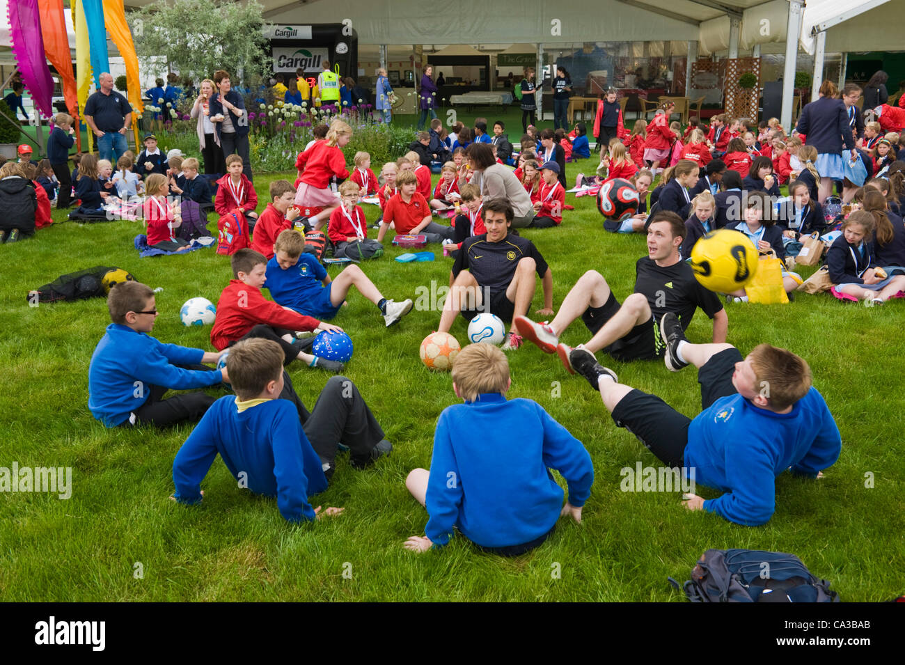 Gli alunni di scuole locali di Powys e Herefordshire Godetevi il pranzo sul prato del festival e mettere in pratica le loro abilità calcistiche presso il Telegraph Hay Festival, Hay-on-Wye, Powys, Wales, Regno Unito Foto Stock