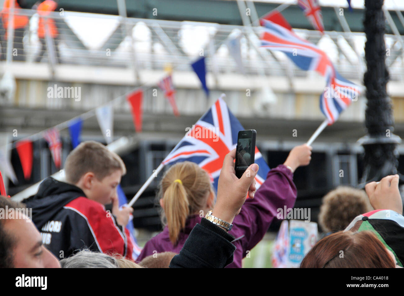 Il 3 giugno 2012. Southbank, Londra, Regno Unito. La folla utilizzare qualsiasi telecamera hanno a fotografare le barche e provare e vedere il corteo sul Tamigi. Foto Stock