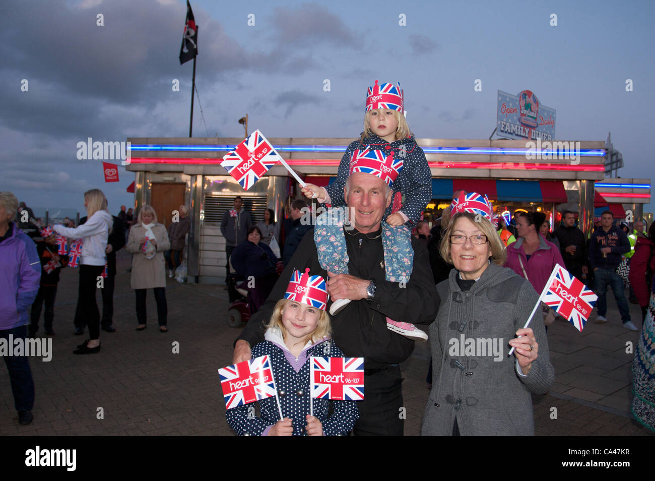 Lunedì 4 Giugno 2012 Great Yarmouth.Norfolk,UK. Grand genitori godendo live band " dopo " shock da Lowestoft con grand bambini, azienda europea bandiere e indossando corone. Celebrando la regina del Giubileo di diamante sul lungomare Great Yarmouth, Regno Unito Foto Stock