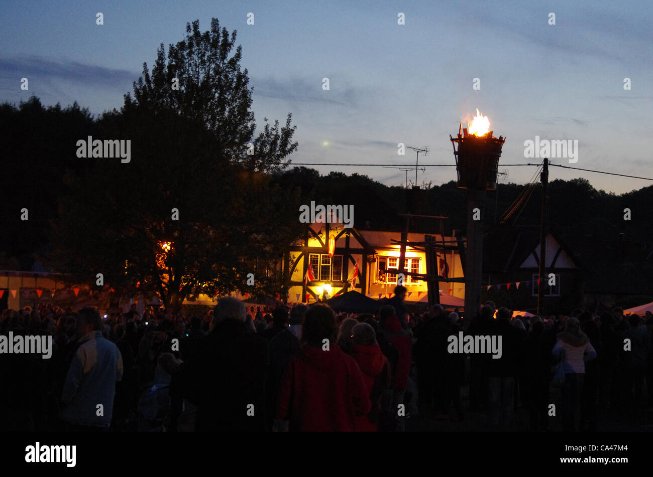 04/06/12. Ley Hill, vicino a Chesham, Buckinghamshire, UK. La folla si riuniscono intorno al faro a luce rotante, dal Crown pub, villaggio della Ley Hill, vicino a Chesham, Buckinghamshire, per celebrare la regina del Giubileo di diamante. Questo a seguito di un giorno di festa su Ley Hill comune dove un Giubileo fayre era detenuto. Foto Stock