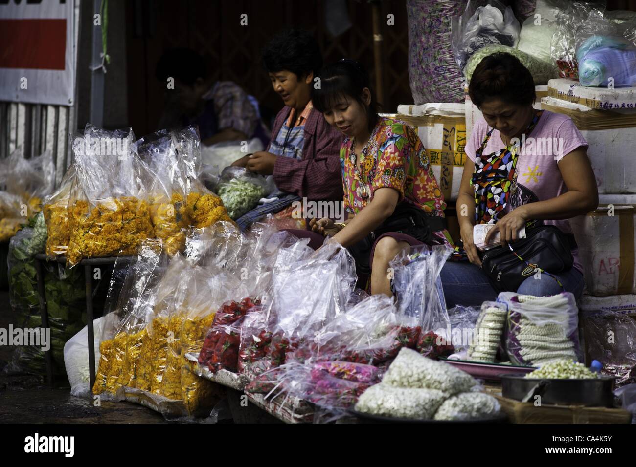 7 giugno 2012 - Bangkok, Thailandia - Flower venditori preparare ghirlande a Bangkok il mercato dei fiori di Giovedì, Giugno 7, 2012 nella capitale Thailandese. Thais usare il mentre ghirlande come offerta a statue buddiste e il loro colore bianco symbolizers la bellezza di gli insegnamenti del Buddha. Quando essi età, essi symboli Foto Stock